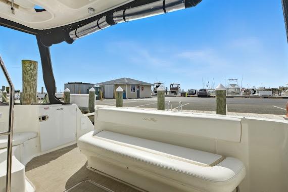 2008 Sea Ray 47 Sedan Bridge yacht interior with marina view, featuring white seating.