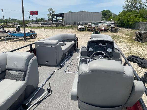2023 Regency 250 DL3 pontoon boat interior with gray seating and dashboard, parked outdoors.