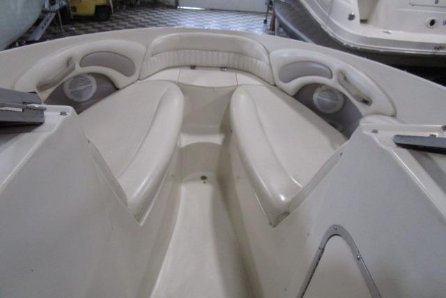 2004 Stingray 240 LR boat interior with white cushioned seating and built-in speakers.