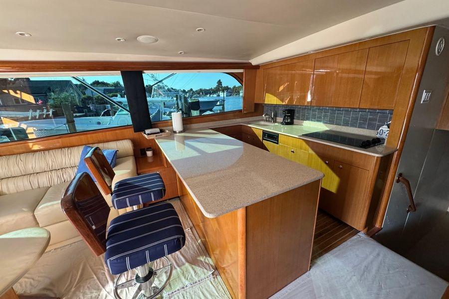 Luxurious interior of 2002 Viking 61 Enclosed Bridge yacht with modern kitchen and seating area.