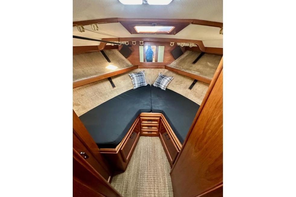 Interior cabin of 1985 Egg Harbor 33 Sedan with cozy bedding and wooden finish.