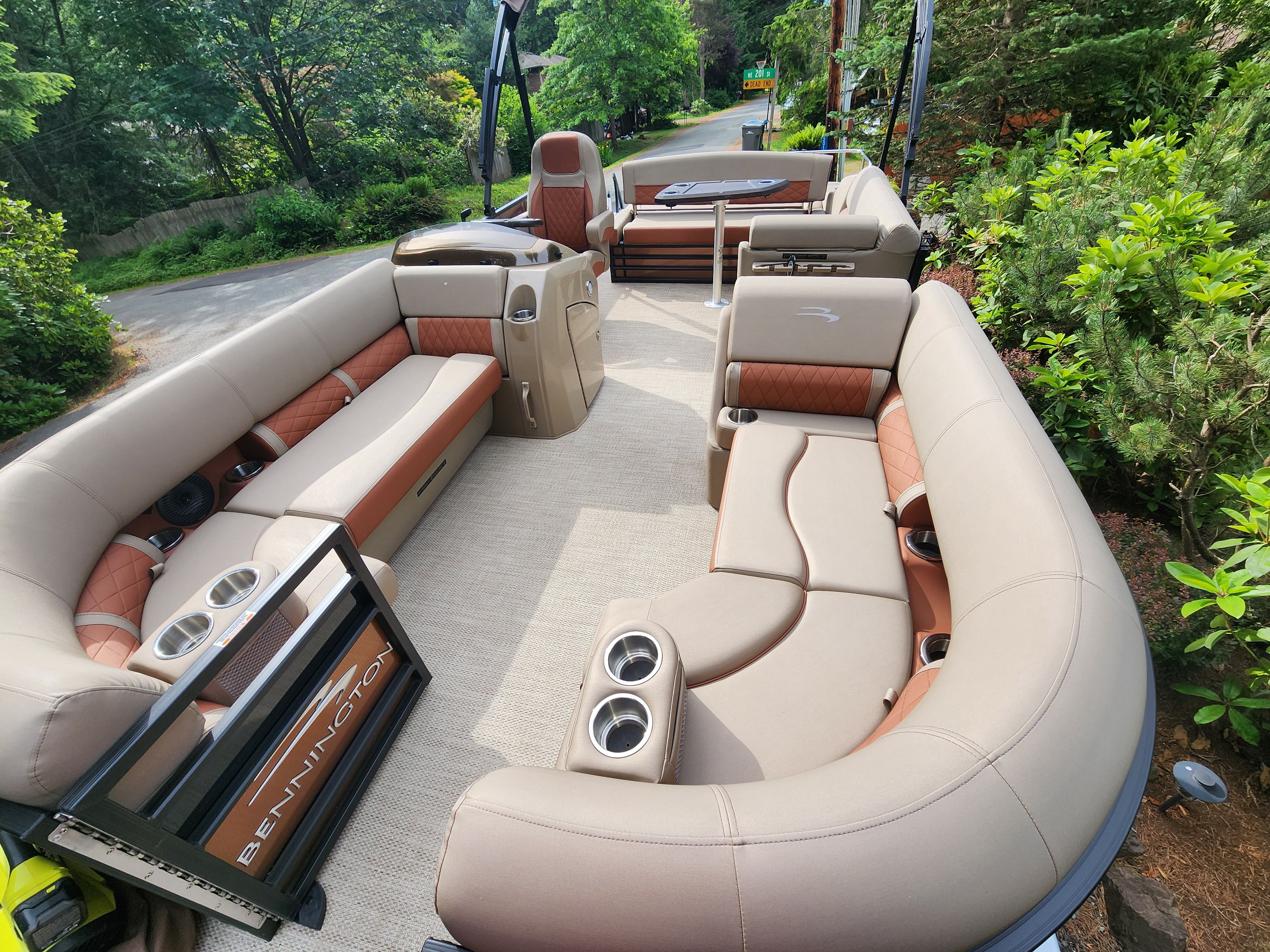 The image shows the interior of a Bennington 22 LSB pontoon boat with beige and brown seating.