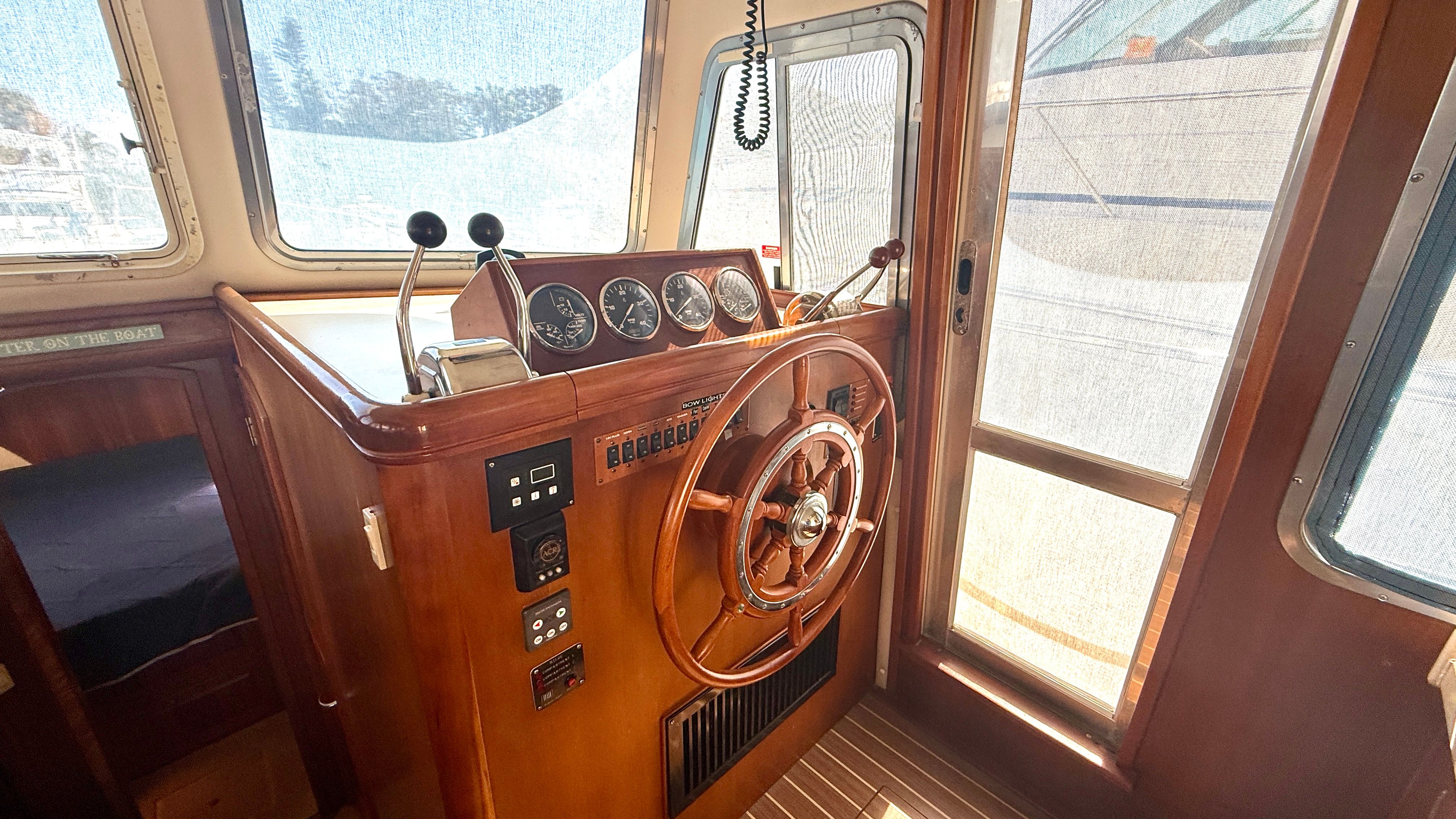2004 Mainship 400 Trawler helm with wooden finish.