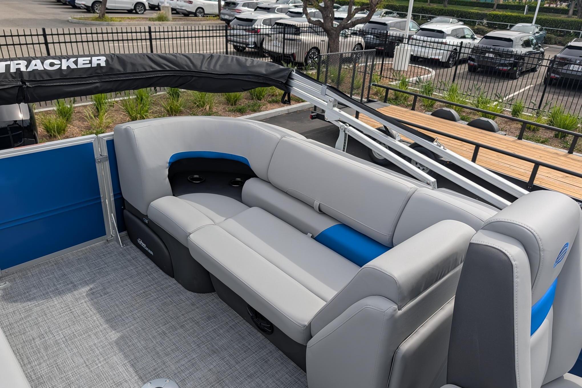 2026 Sun Tracker Party Barge 22 DLX with plush seating and modern design in a parking lot.