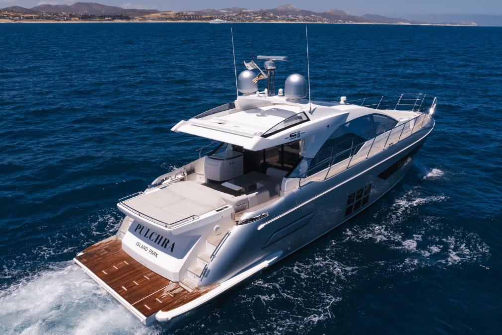 Azimut 60 yacht cruising on open sea, 2020 model, with scenic coastal backdrop.