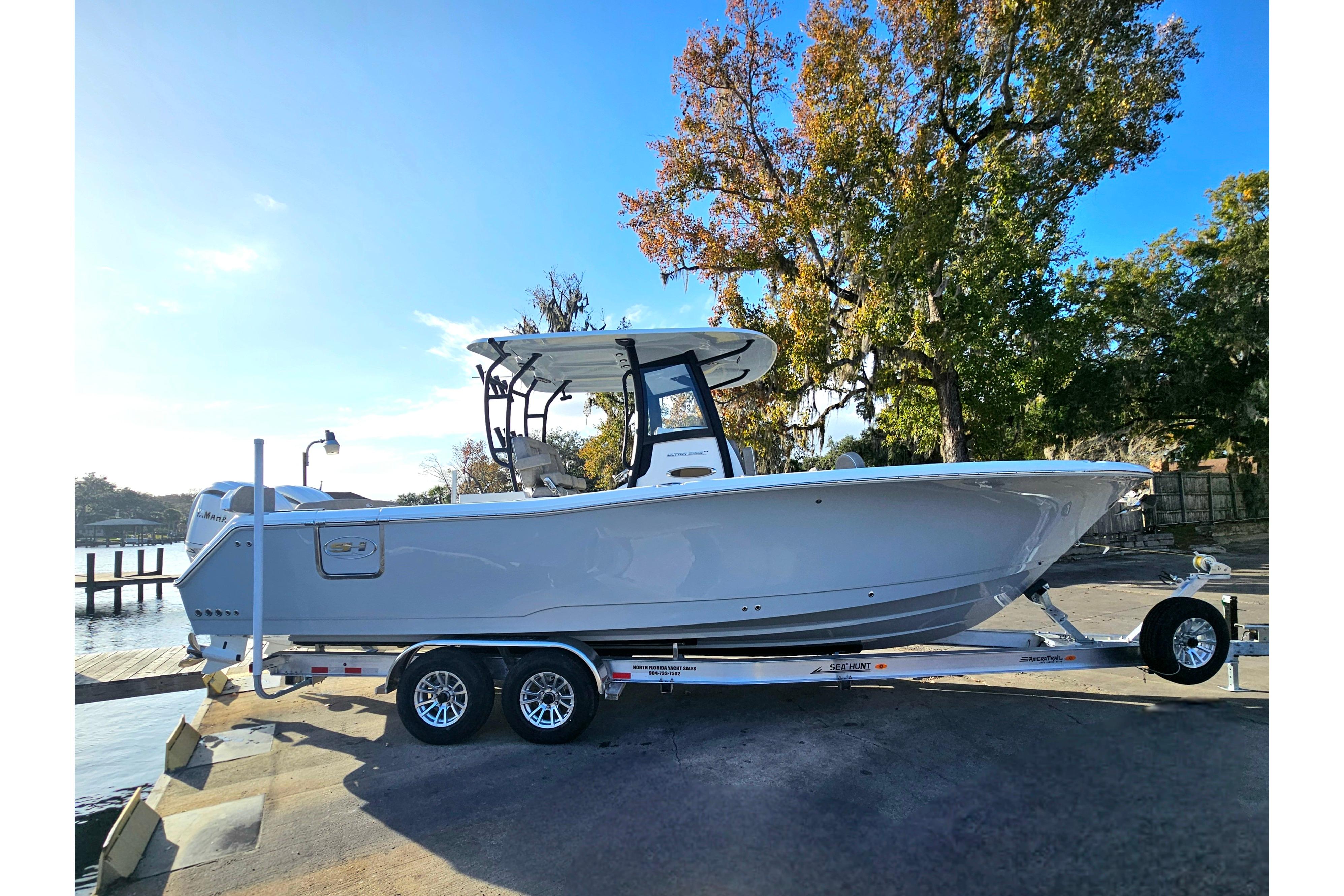 2026 Sea Hunt Ultra 285 SE boat on trailer, parked near water.