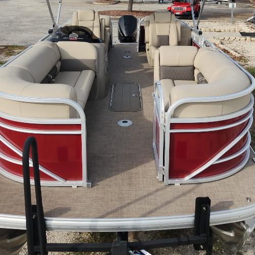 2023 Sun Tracker Party Barge 22 XP3 pontoon boat with beige seating and red exterior.