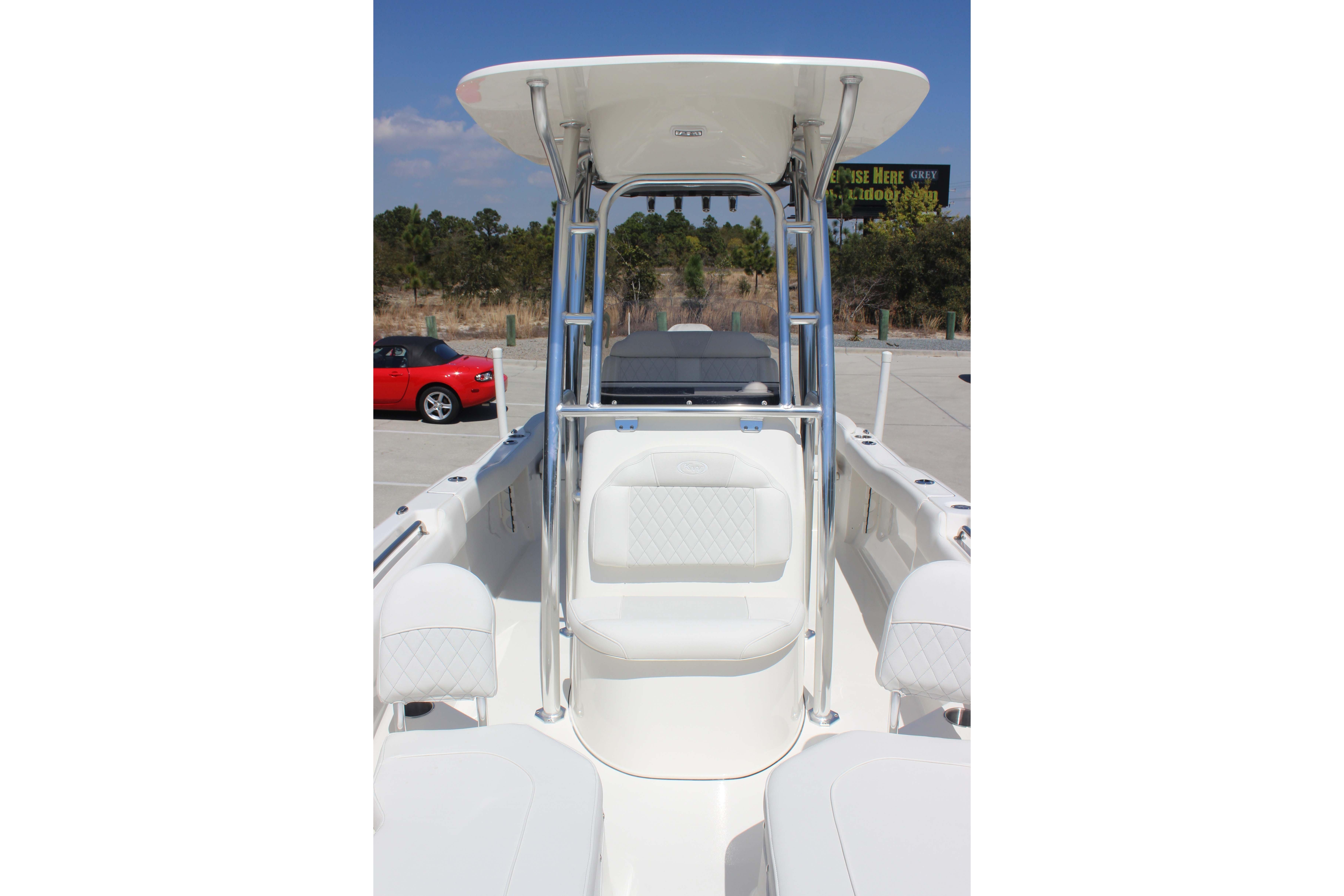 2026 Key West 203 FS boat interior with seating and T-top in a parking lot.