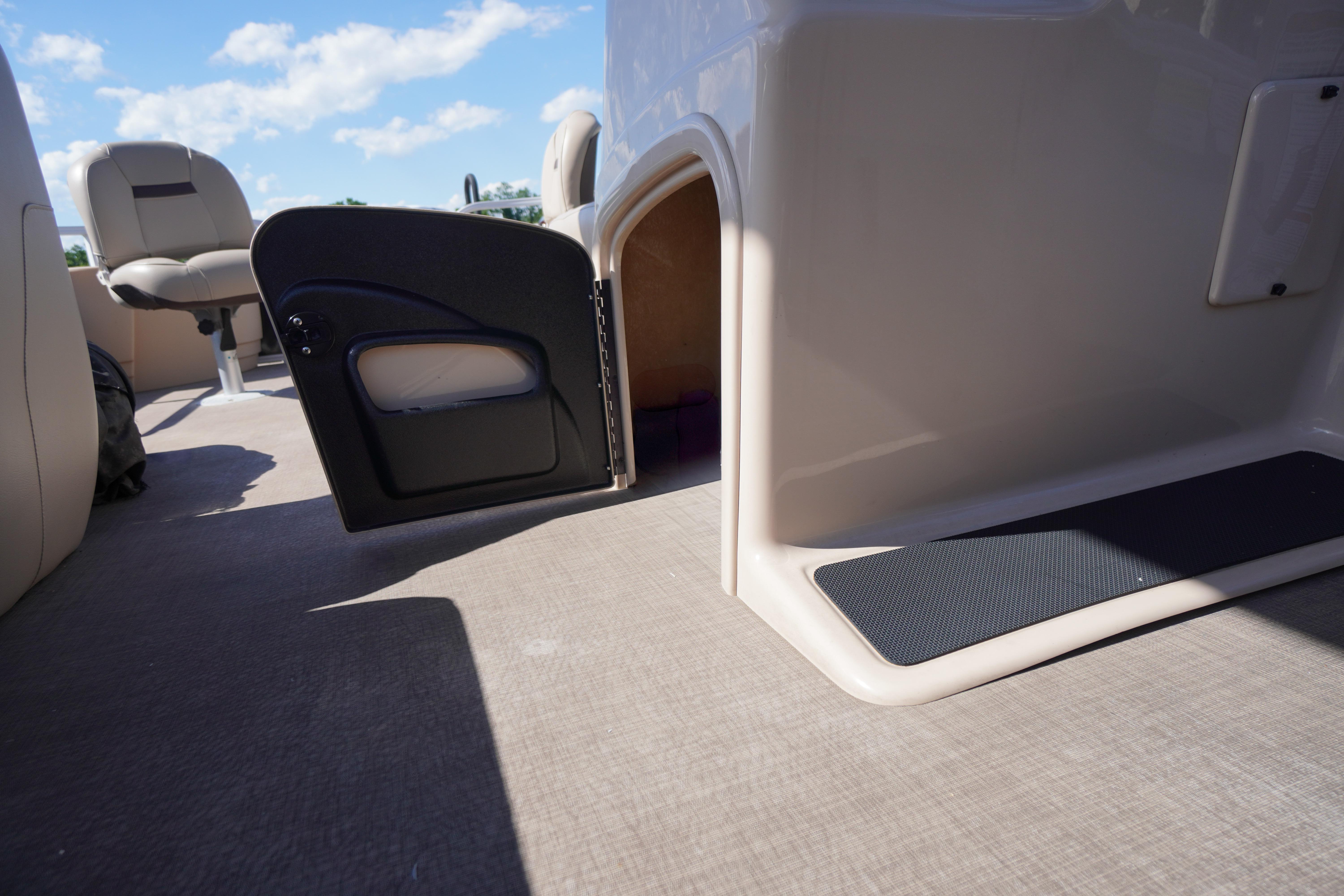 2019 SUNTRACKER Fishin' Barge 22 DLX interior with open storage compartment and seating.