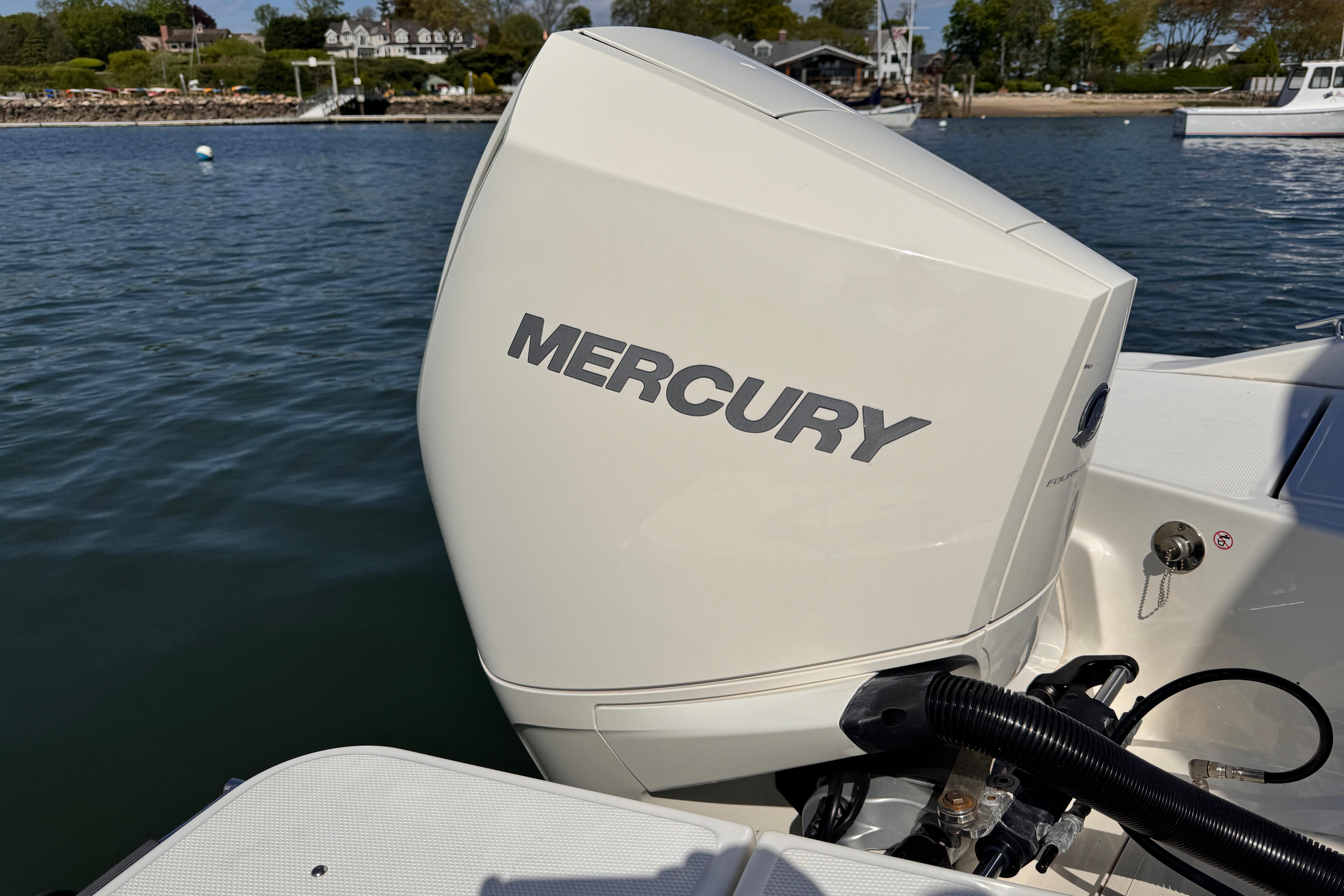 2022 Boston Whaler 220 Dauntless with Mercury outboard engine on calm water.