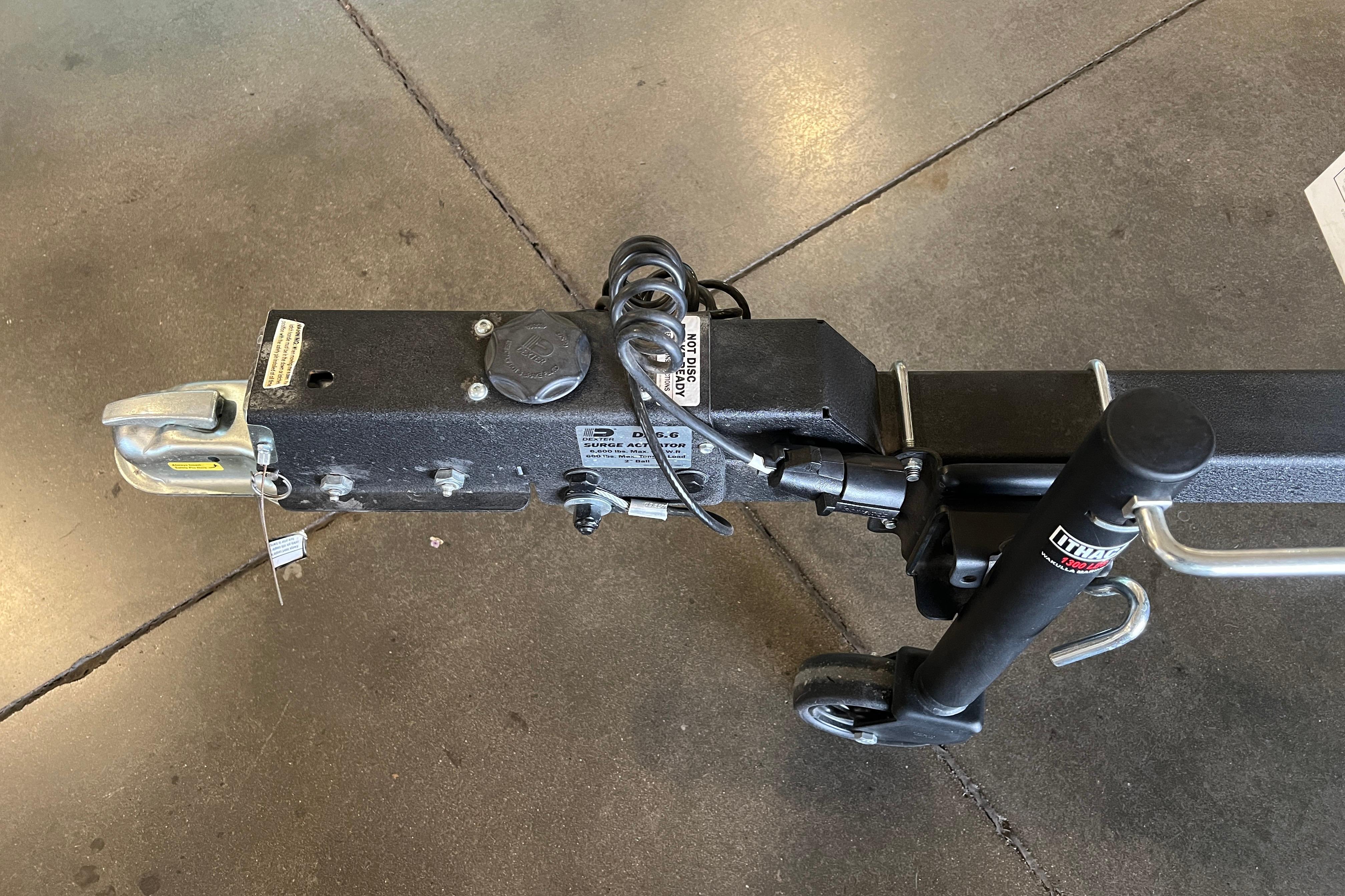 Trailer hitch and jack of 2026 Tracker Grizzly 1860 CC on concrete floor.