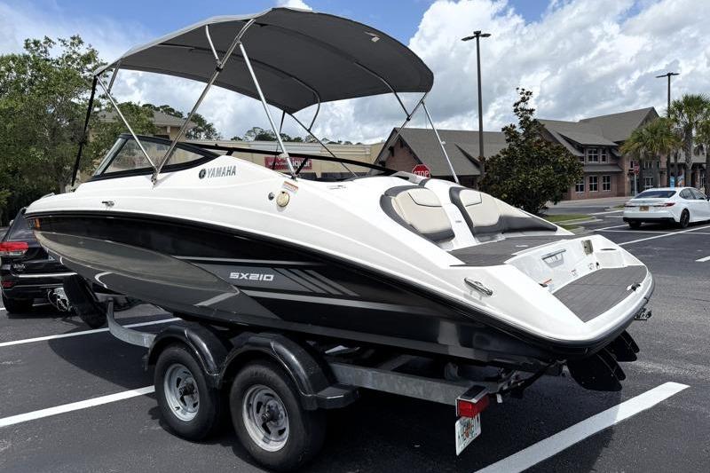 2017 Yamaha Boats SX210 on trailer in parking lot, featuring sleek design and canopy.