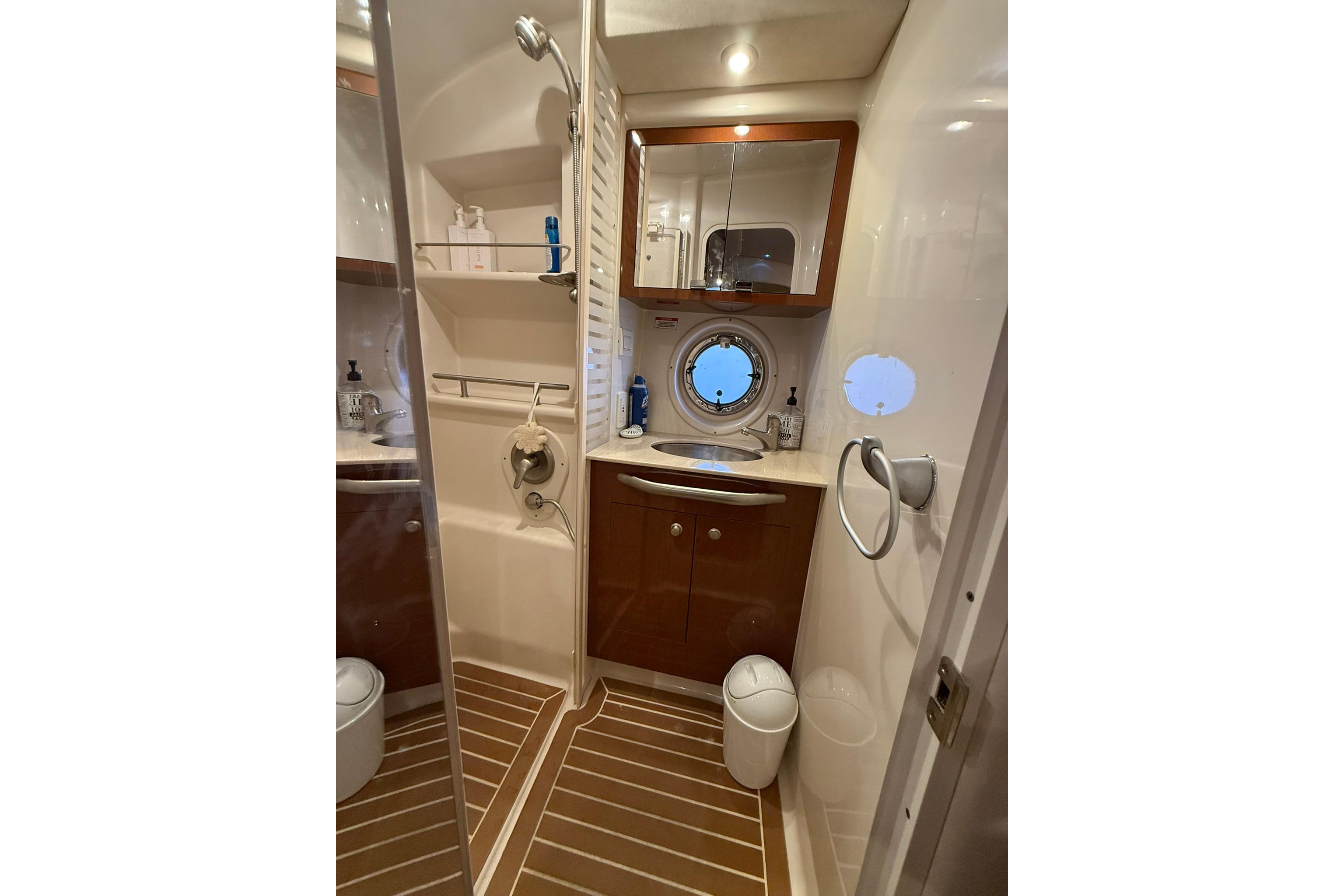 Luxurious bathroom in 2009 Sea Ray 350 Sundancer yacht with modern fixtures and porthole window.