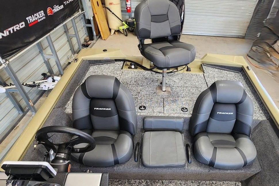2026 Tracker Pro Team 195 boat interior with three gray seats and steering wheel.