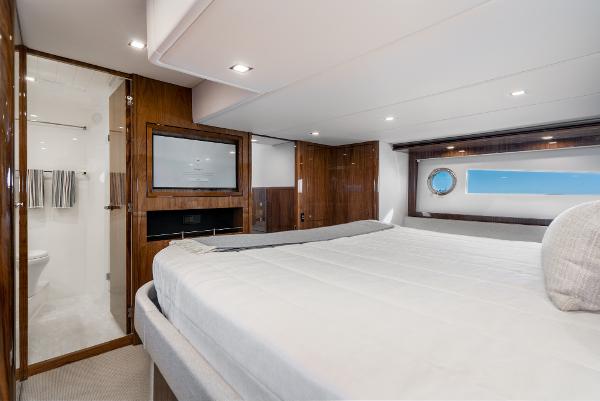 Luxurious bedroom interior of 2021 Riviera 5400 Sport Yacht with ensuite bathroom.