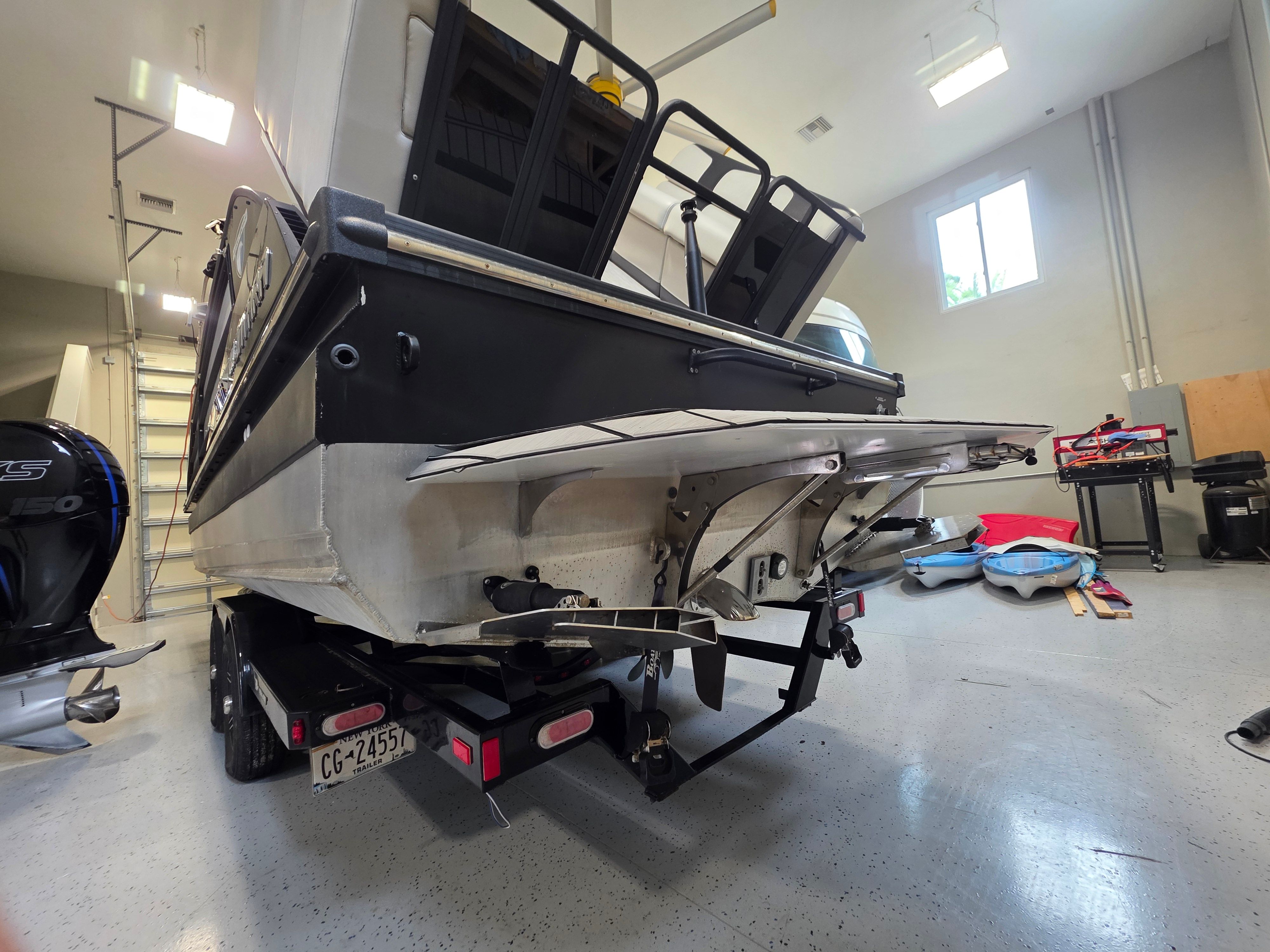 Rear view of a 2021 Montara SURF BOSS 25 boat in a workshop.