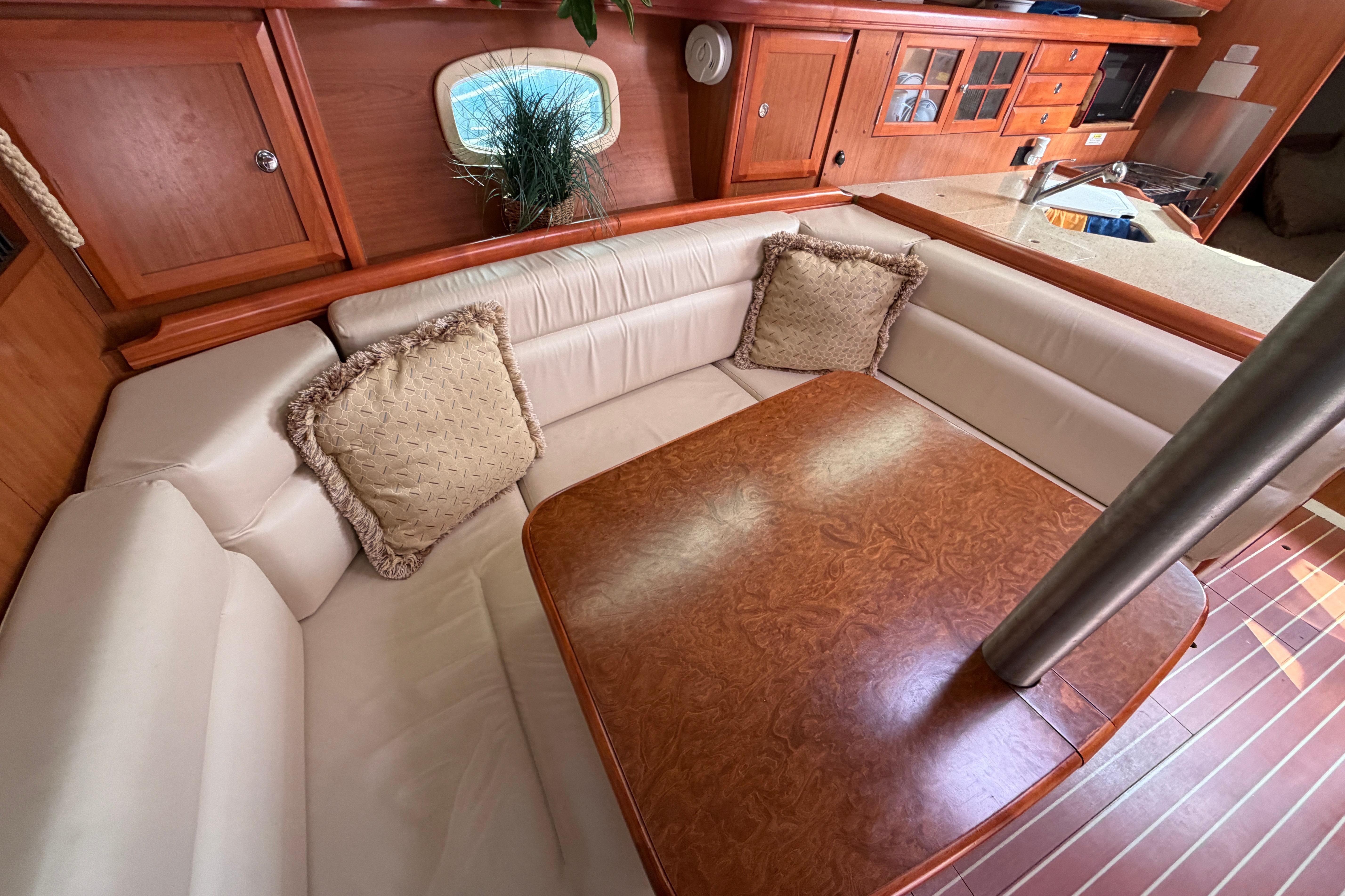 Luxurious interior of a 2008 Hunter 36 sailboat with plush seating and wooden table.