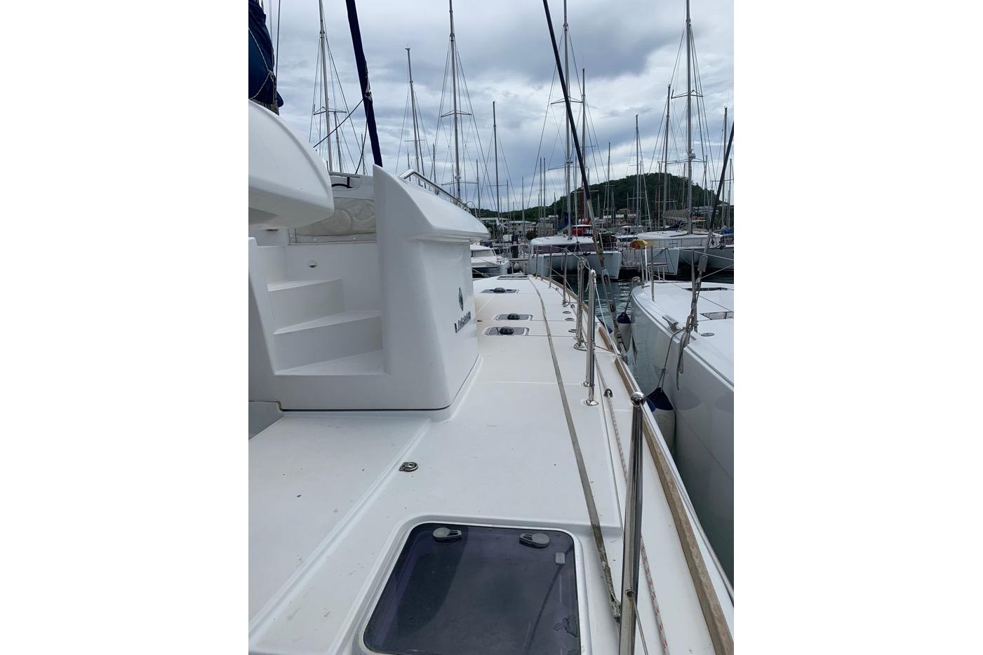 2018 Lagoon 450 F catamaran docked in a marina, surrounded by other boats.