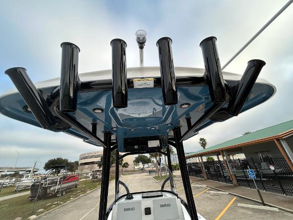 2024 Sea Pro 250 DLX boat with rod holders and T-top, docked in a marina.