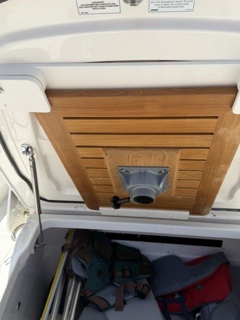 Storage compartment in 2023 Boston Whaler 330 Outrage with wooden paneling.