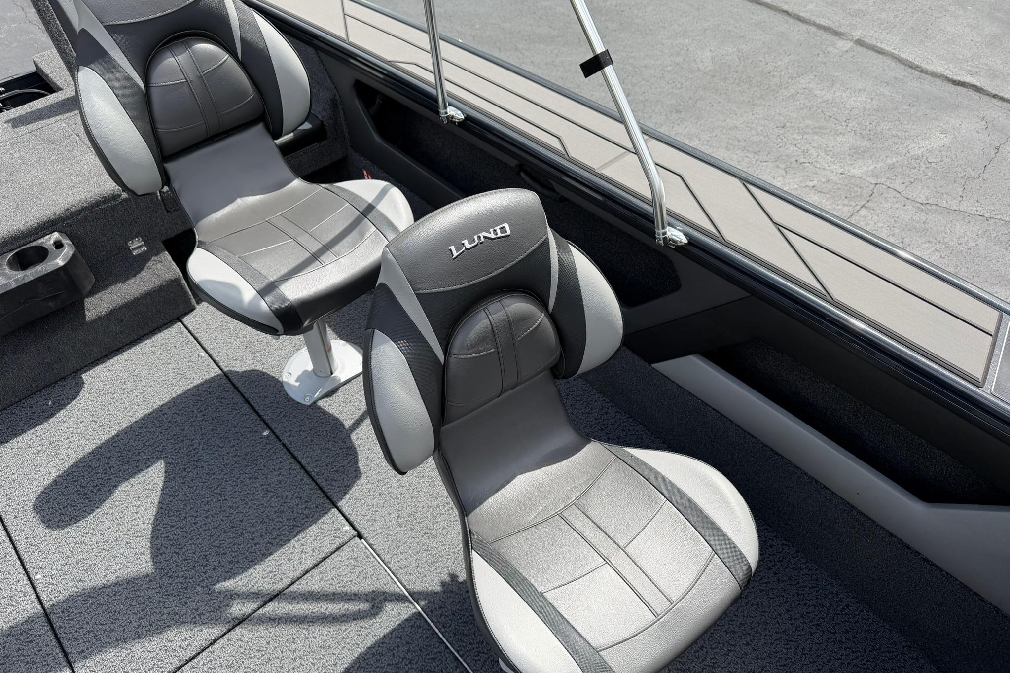 2027 Lund 1875 Crossover XS boat interior with two gray seats and carpeted flooring.