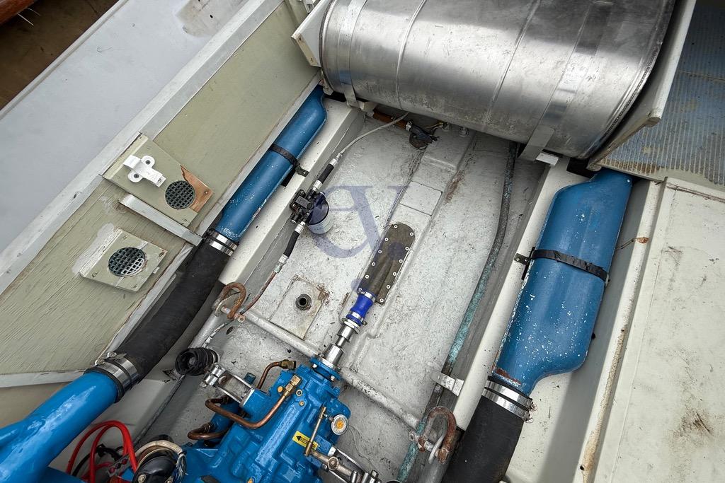 Engine compartment of a 1972 Riva Rudy boat, showcasing mechanical components and blue piping.