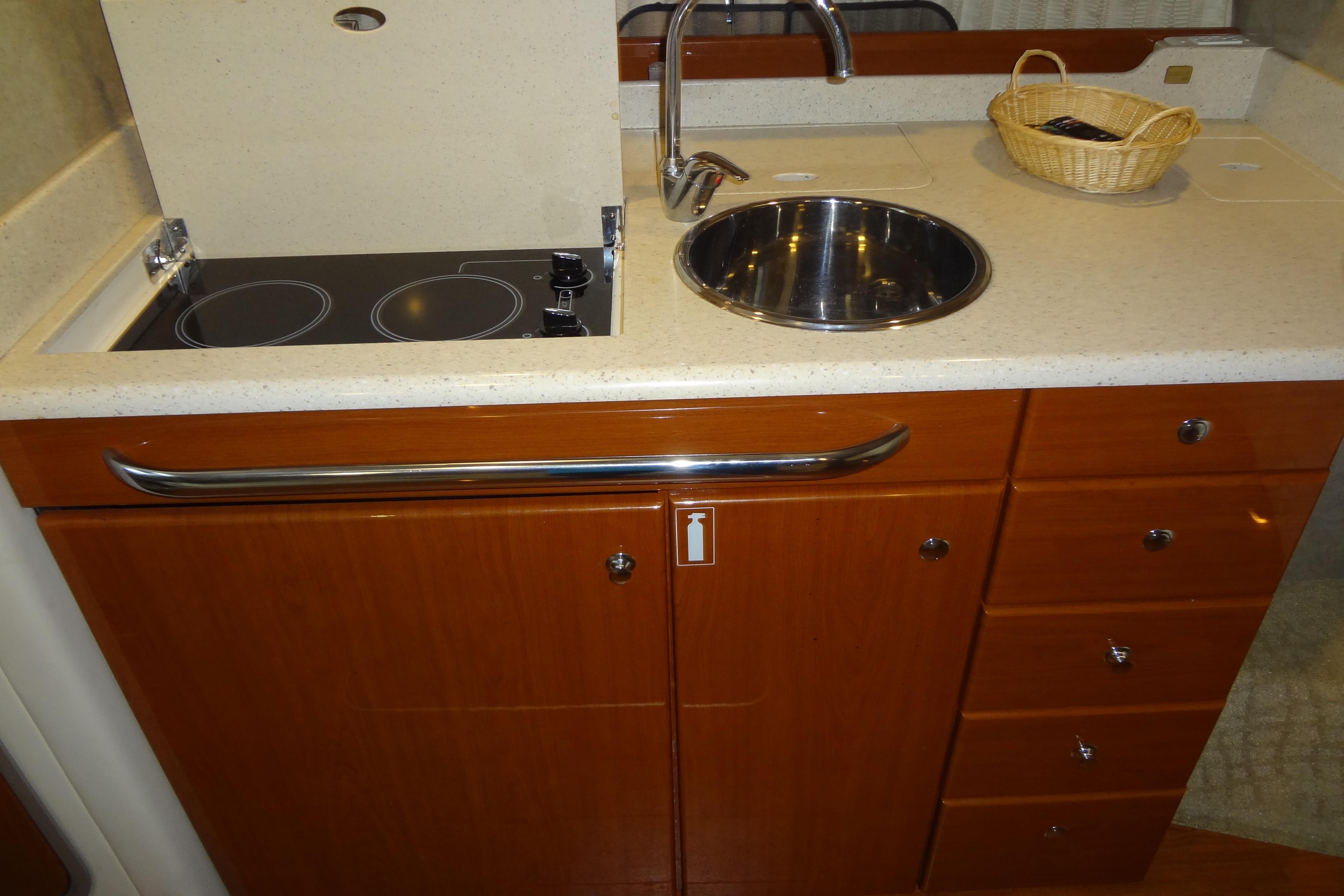 2007 Formula 34 Performance Cruiser kitchen with stove, sink, and wooden cabinetry.