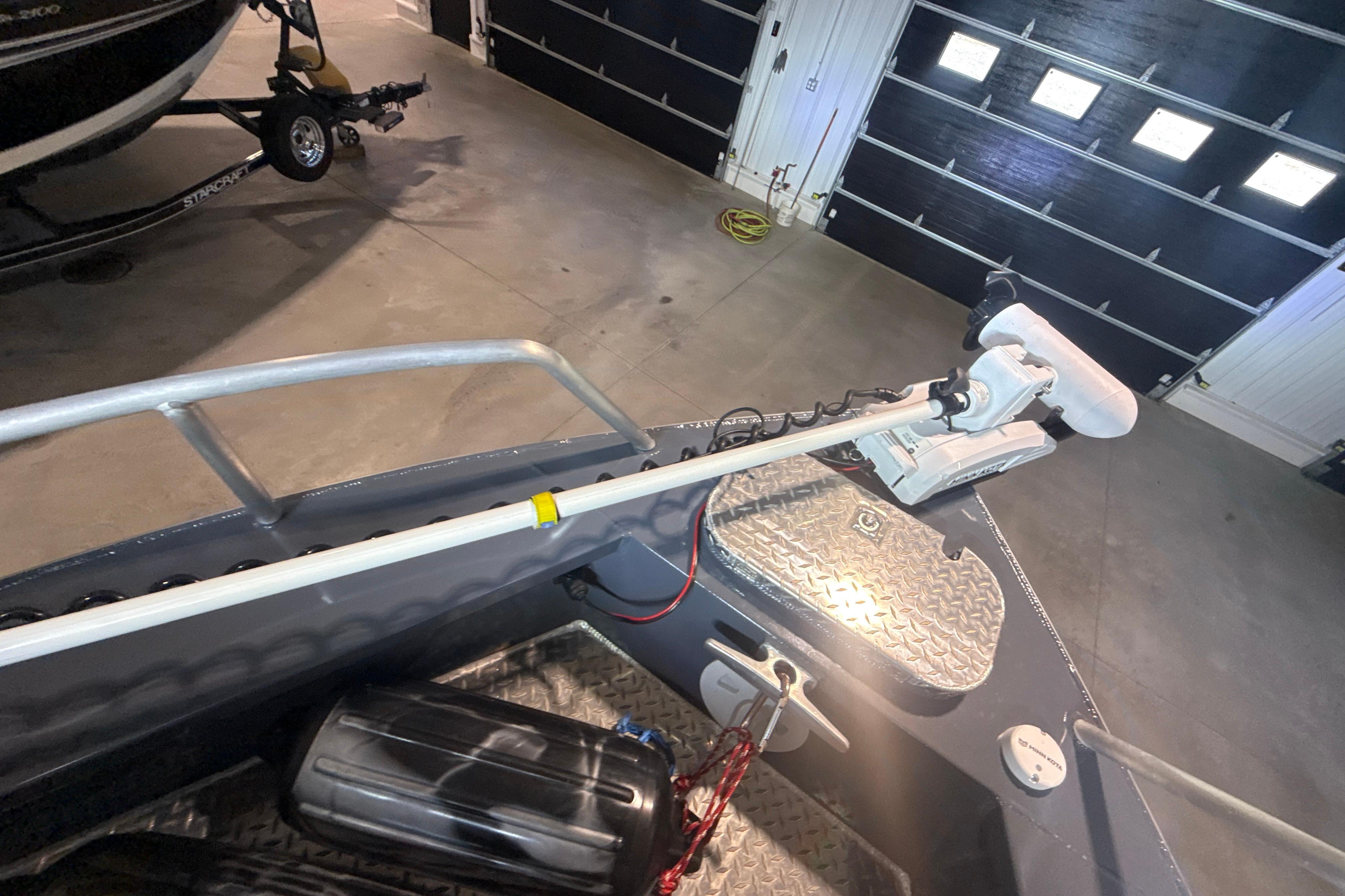 2022 Hewescraft 270 Alaskan Hardtop boat with mounted trolling motor in garage.