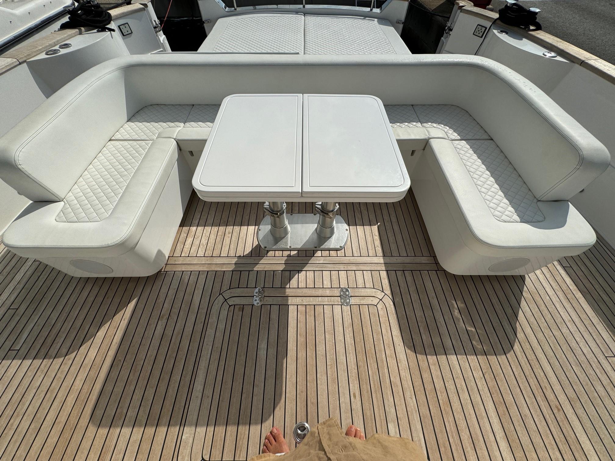 Luxury seating area on 2022 Apreamare Gozzo 45 yacht with white cushions and wooden deck.