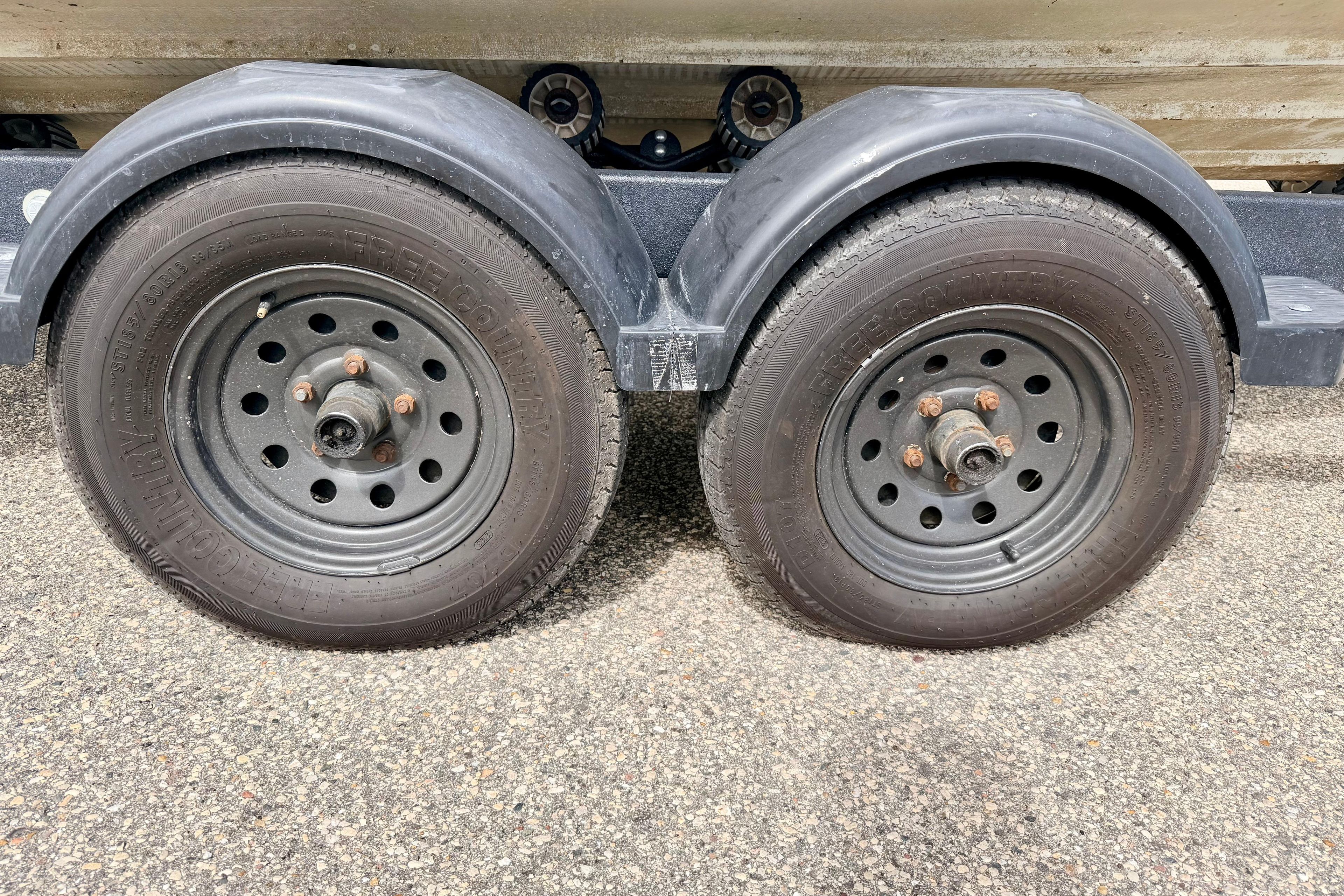Trailer wheels for 2003 Sea Ray 200 Sundeck on asphalt surface.
