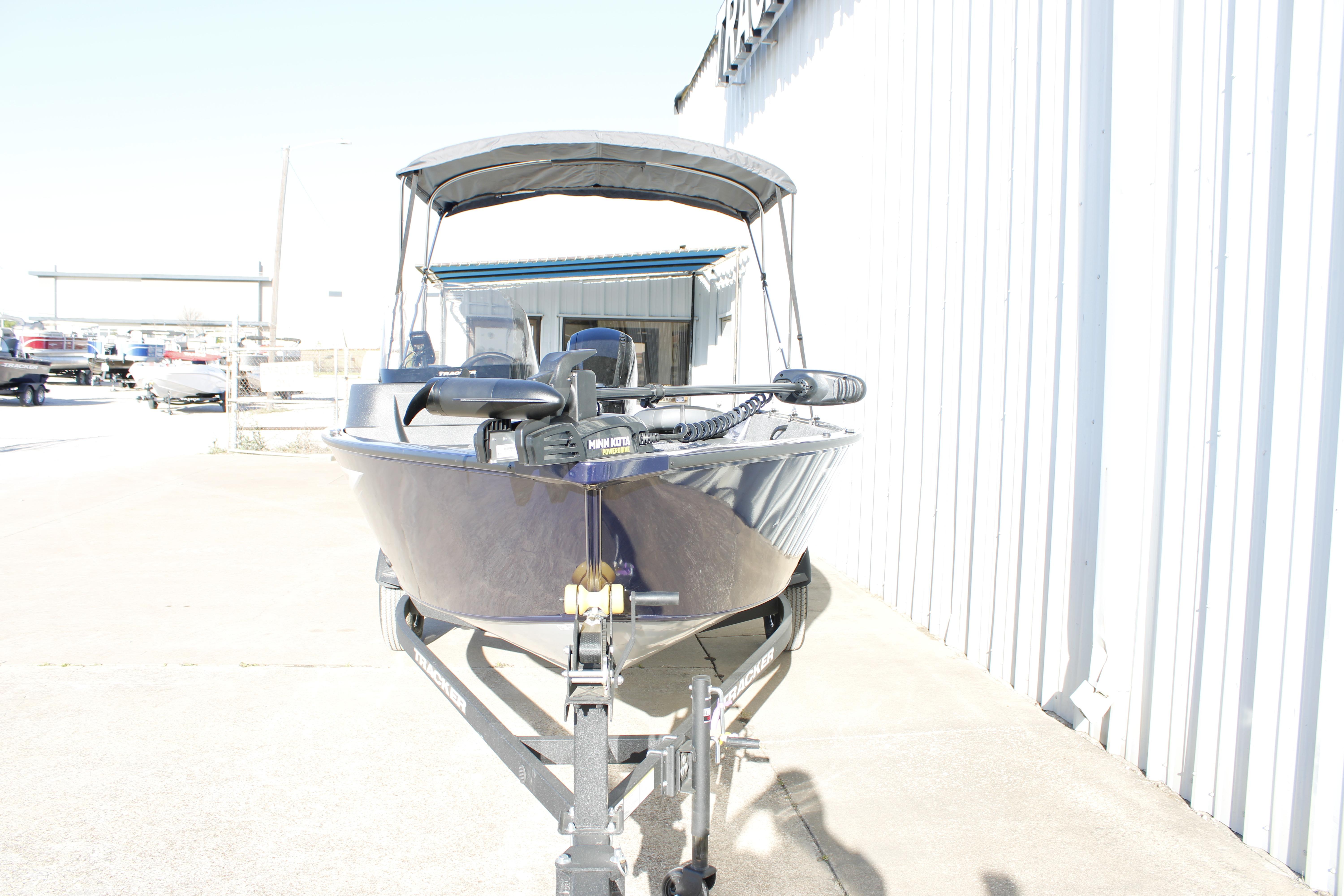 2026 Tracker Pro Guide V-16 SC boat on trailer, parked outdoors near a building.