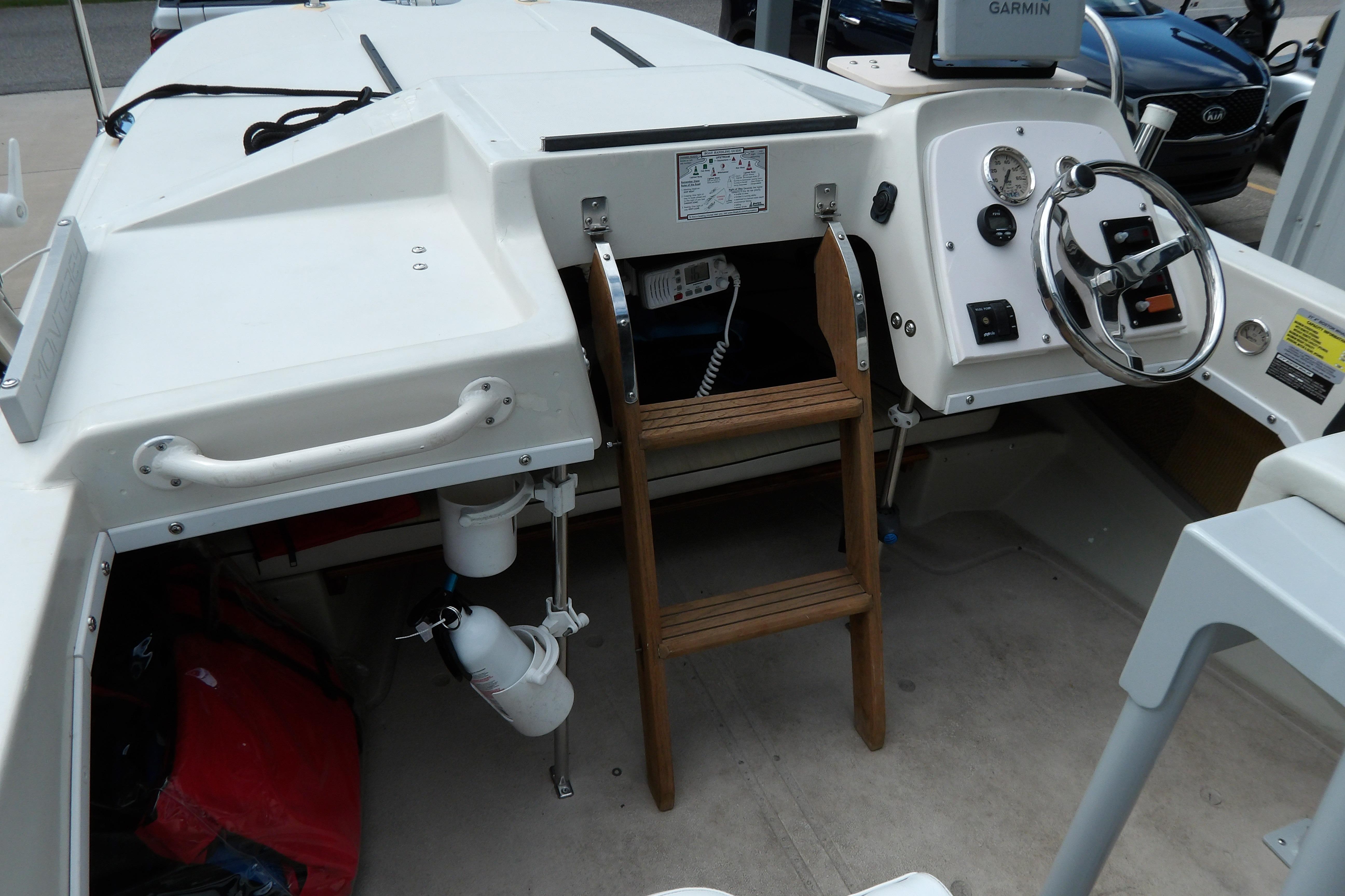 1978 Boston Whaler 21 Revenge boat interior with steering wheel and wooden ladder.