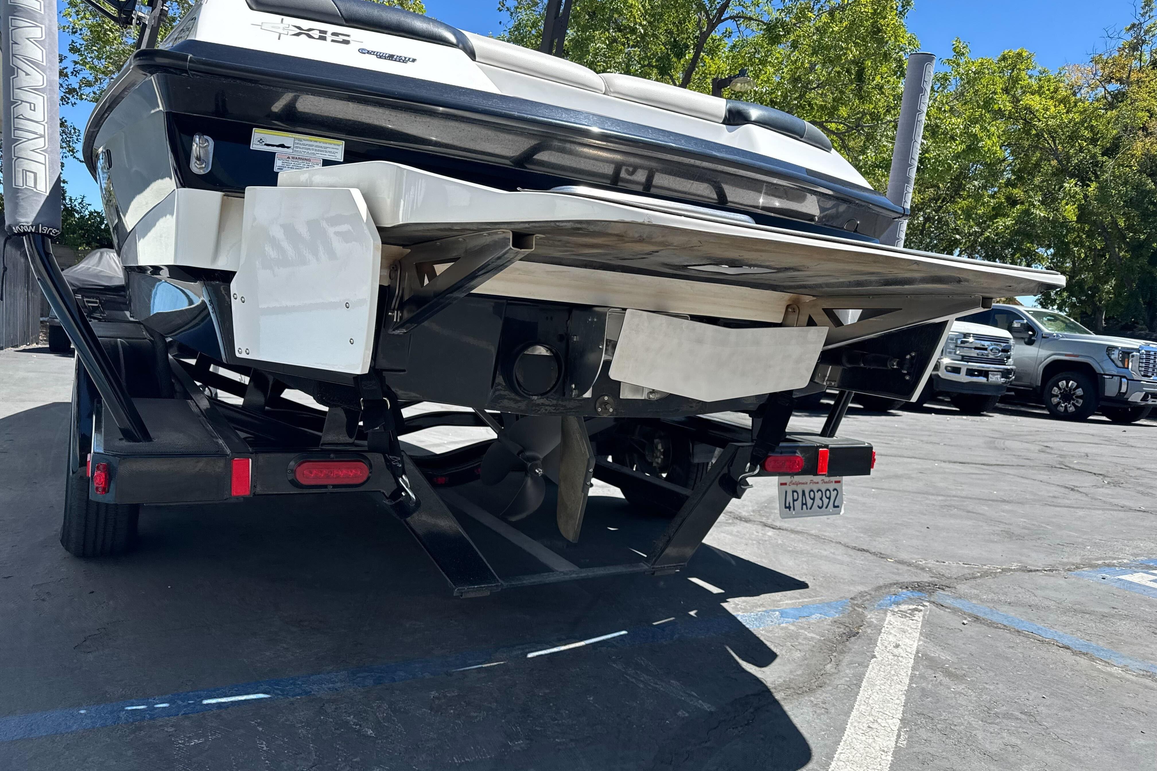 2015 Axis A20 boat on trailer, rear view, parked outdoors.