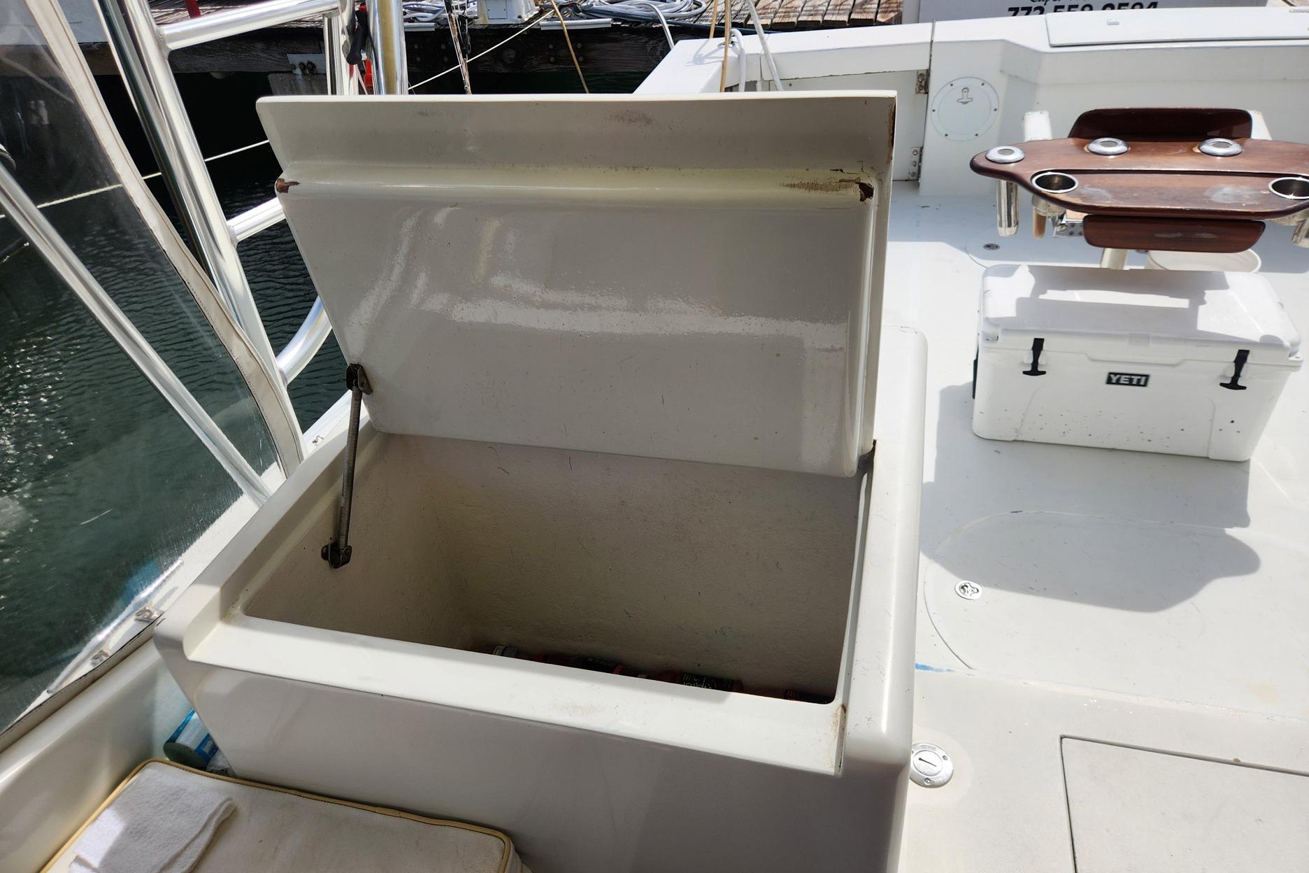 Open storage compartment on 1987 Young Brothers Custom Sport Fish boat deck.
