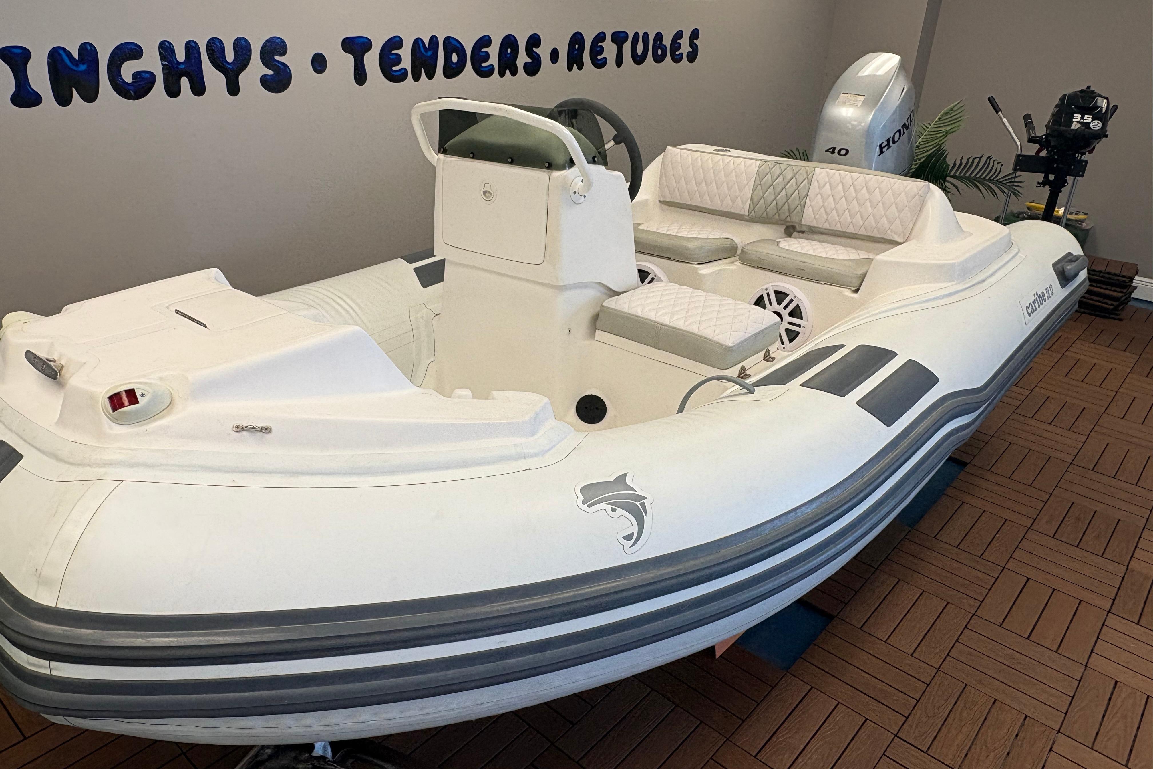 2019 Caribe DL12 inflatable boat with seating, displayed indoors on wooden flooring.