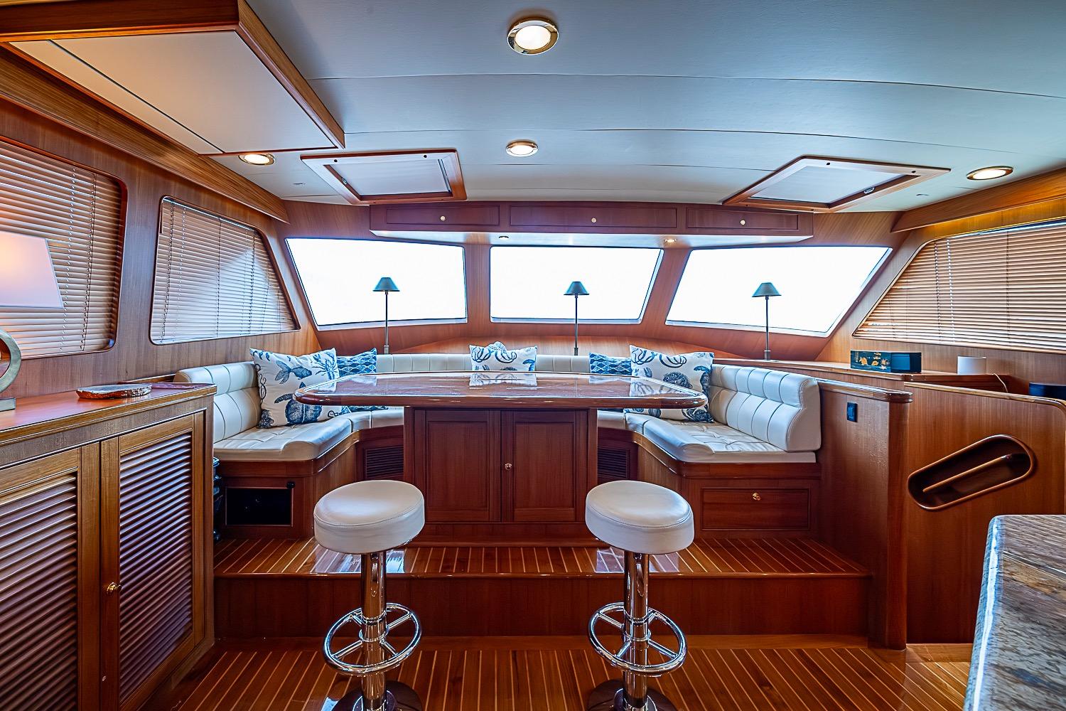 Luxurious interior of 2014 Marlow 80 Explorer yacht with elegant seating and wooden finishes.