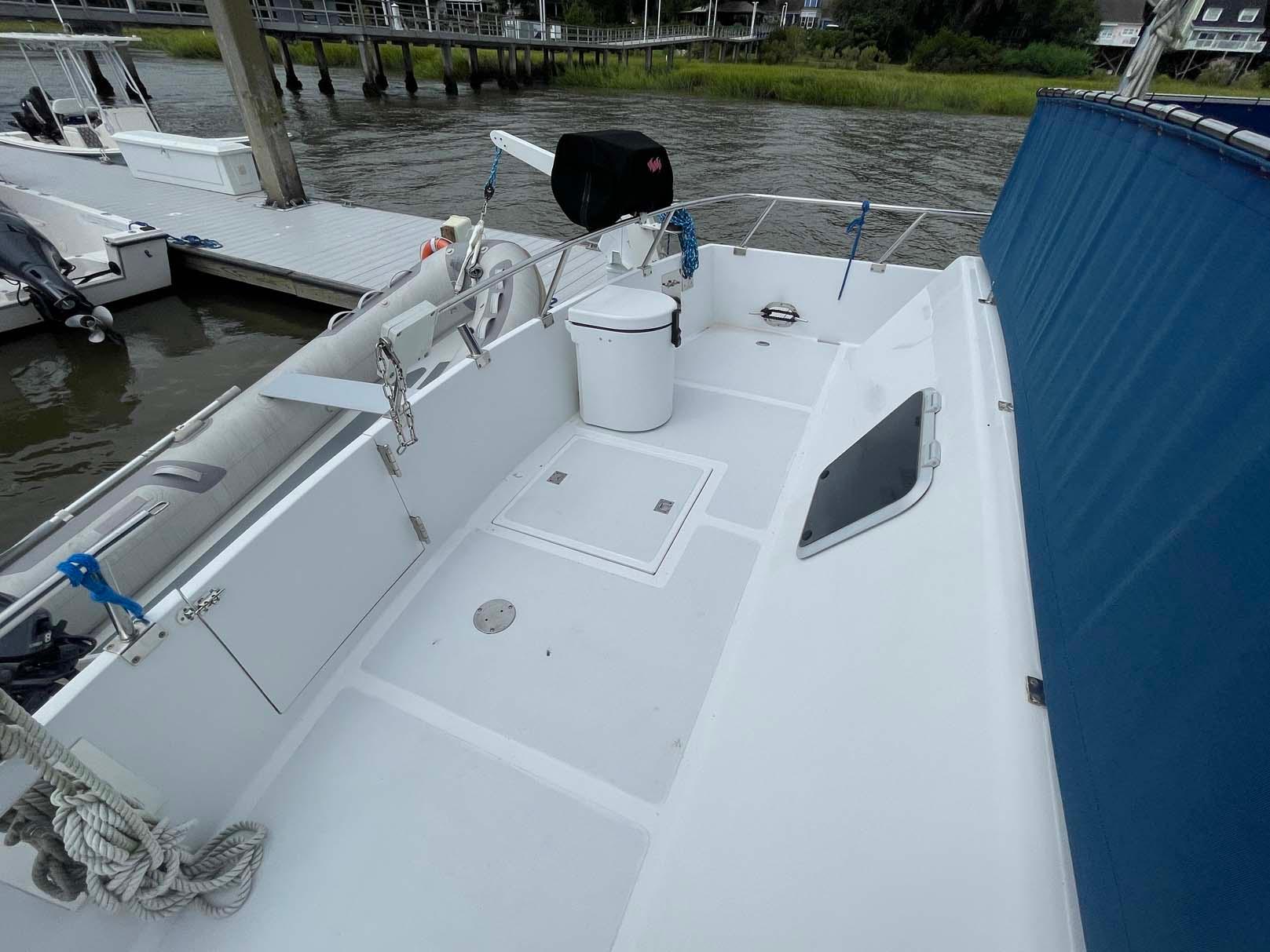 1985 DeFever 40 Offshore Cruiser deck with railing, docked by the water.