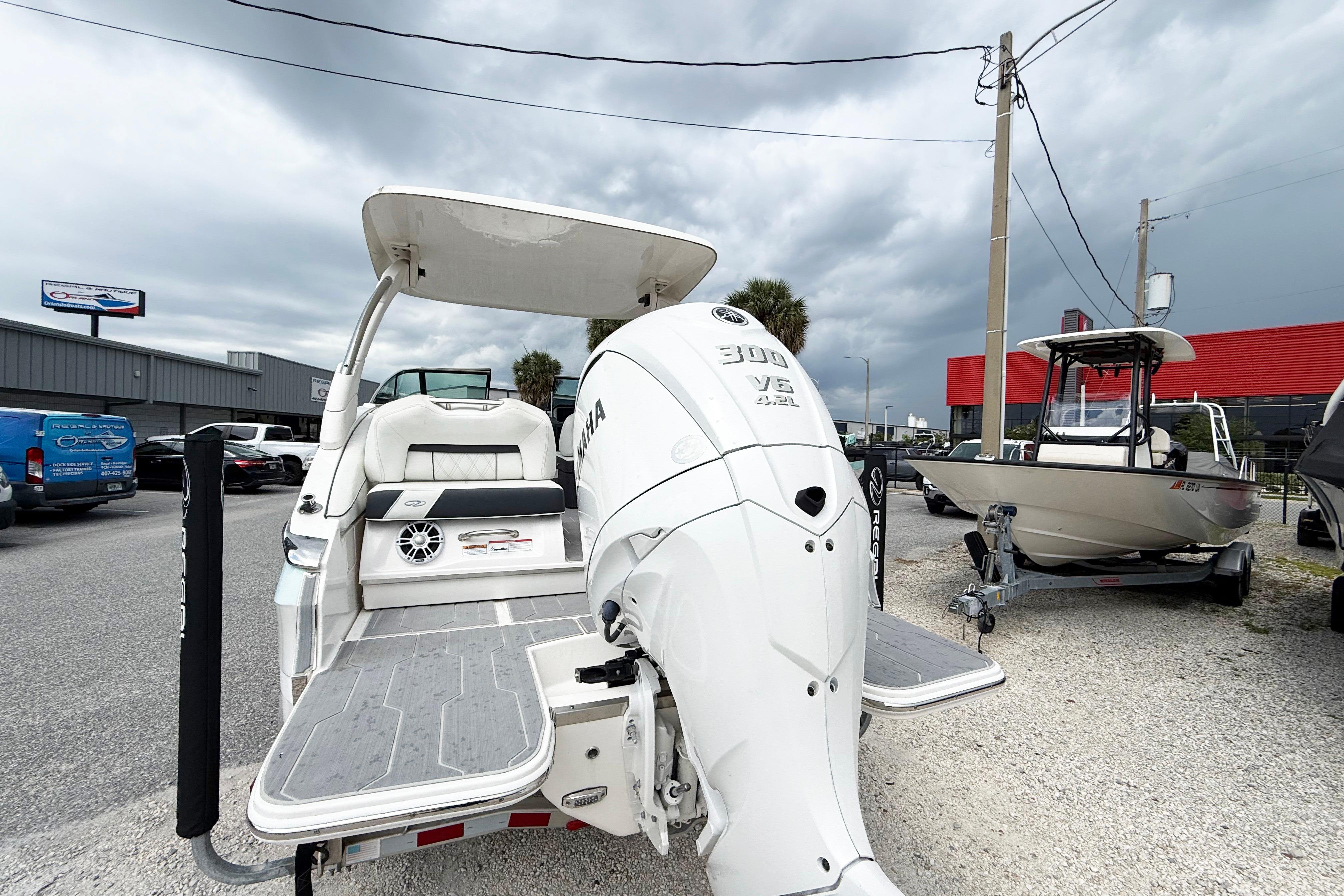 2024 Regal LX4 boat with Yamaha 300 V6 engine, displayed outdoors on gravel.