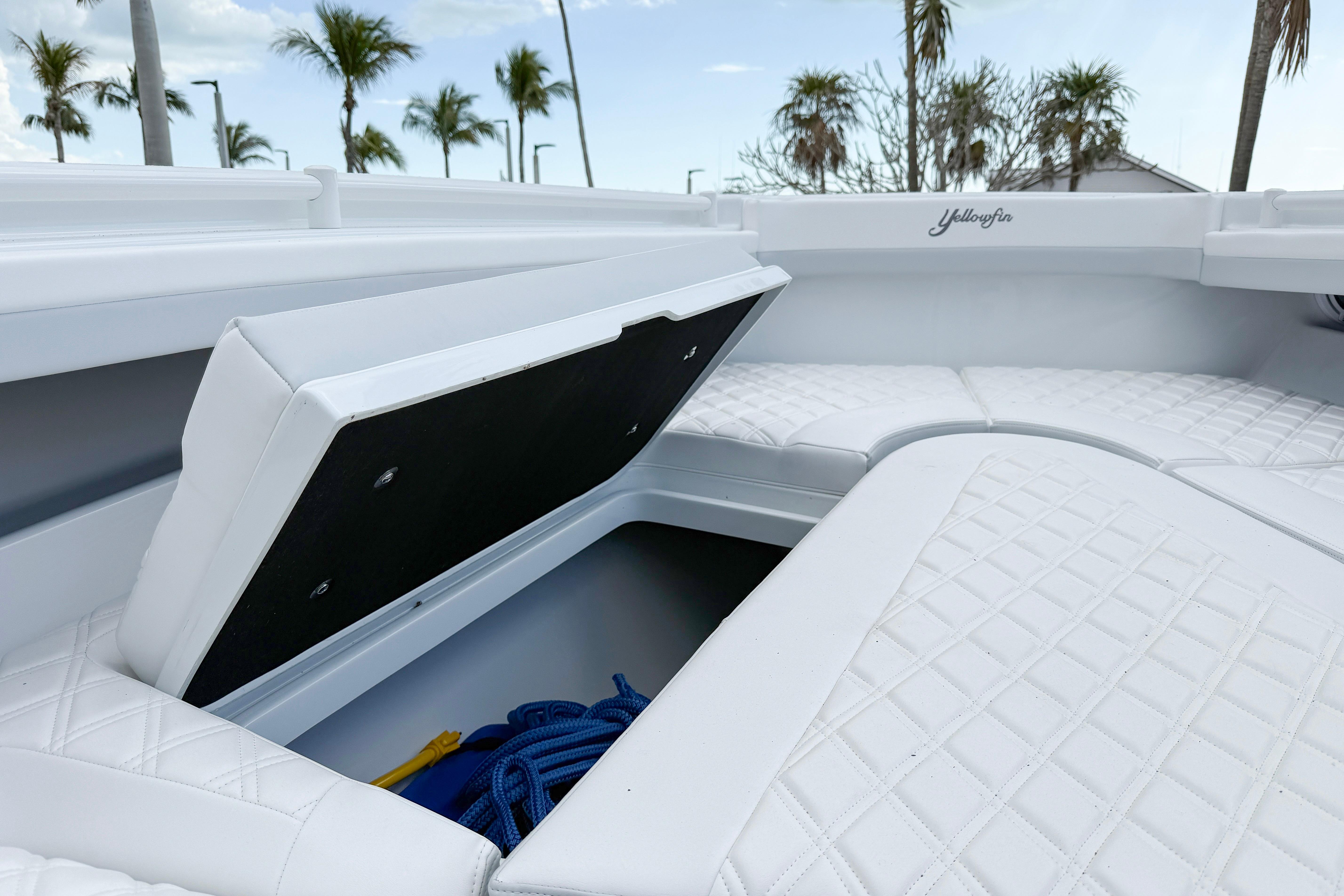 2024 Yellowfin 34 Offshore boat with open storage compartment and white quilted seating.