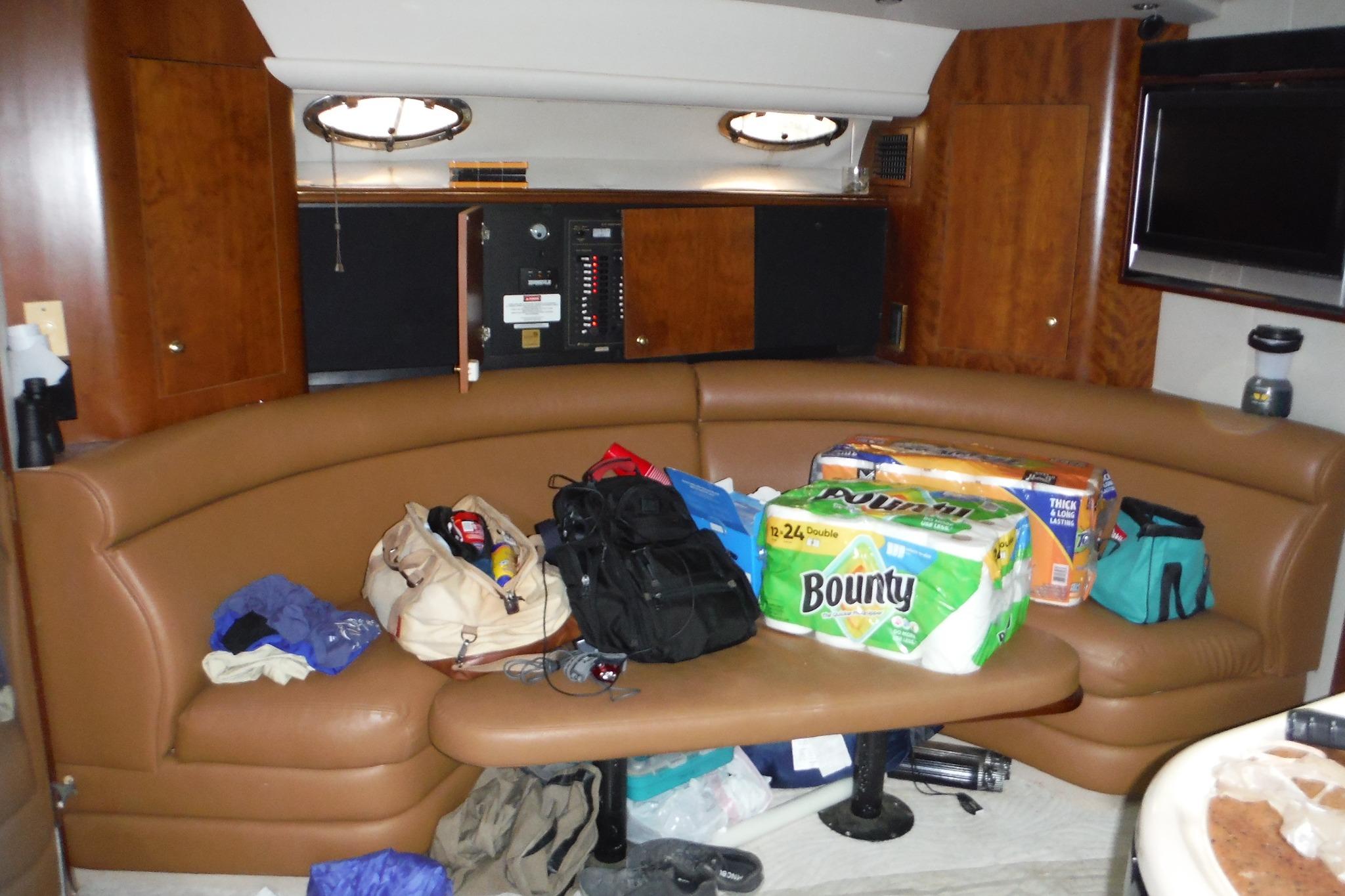 1999 Cruisers 4270 Express yacht interior with brown seating and various supplies.