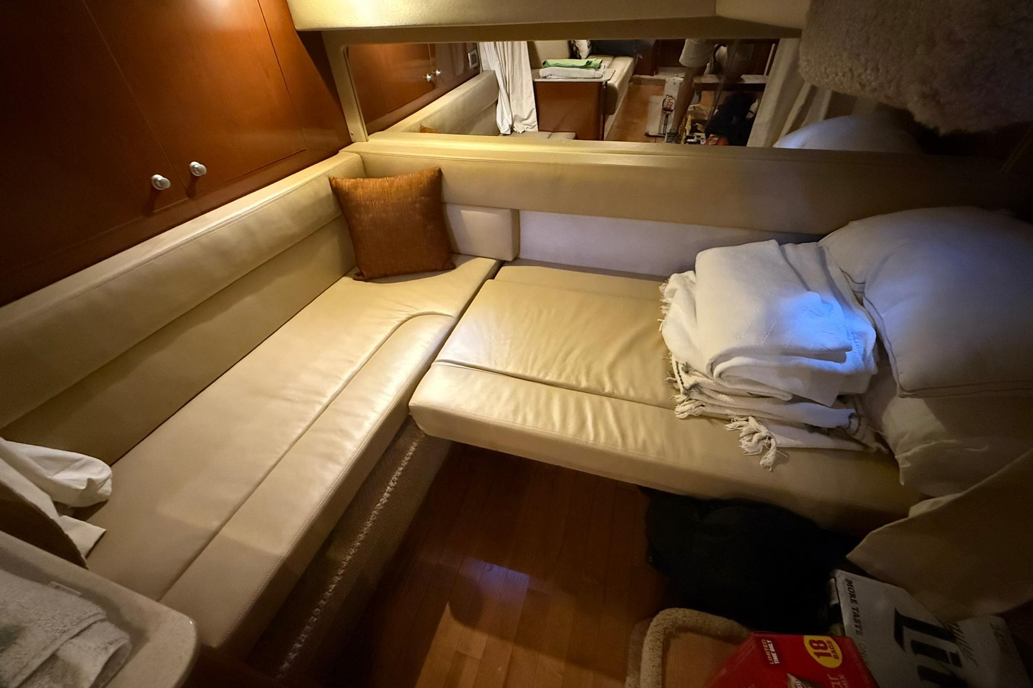 Interior of 2009 Sea Ray 350 Sundancer with beige seating and cozy cushions.