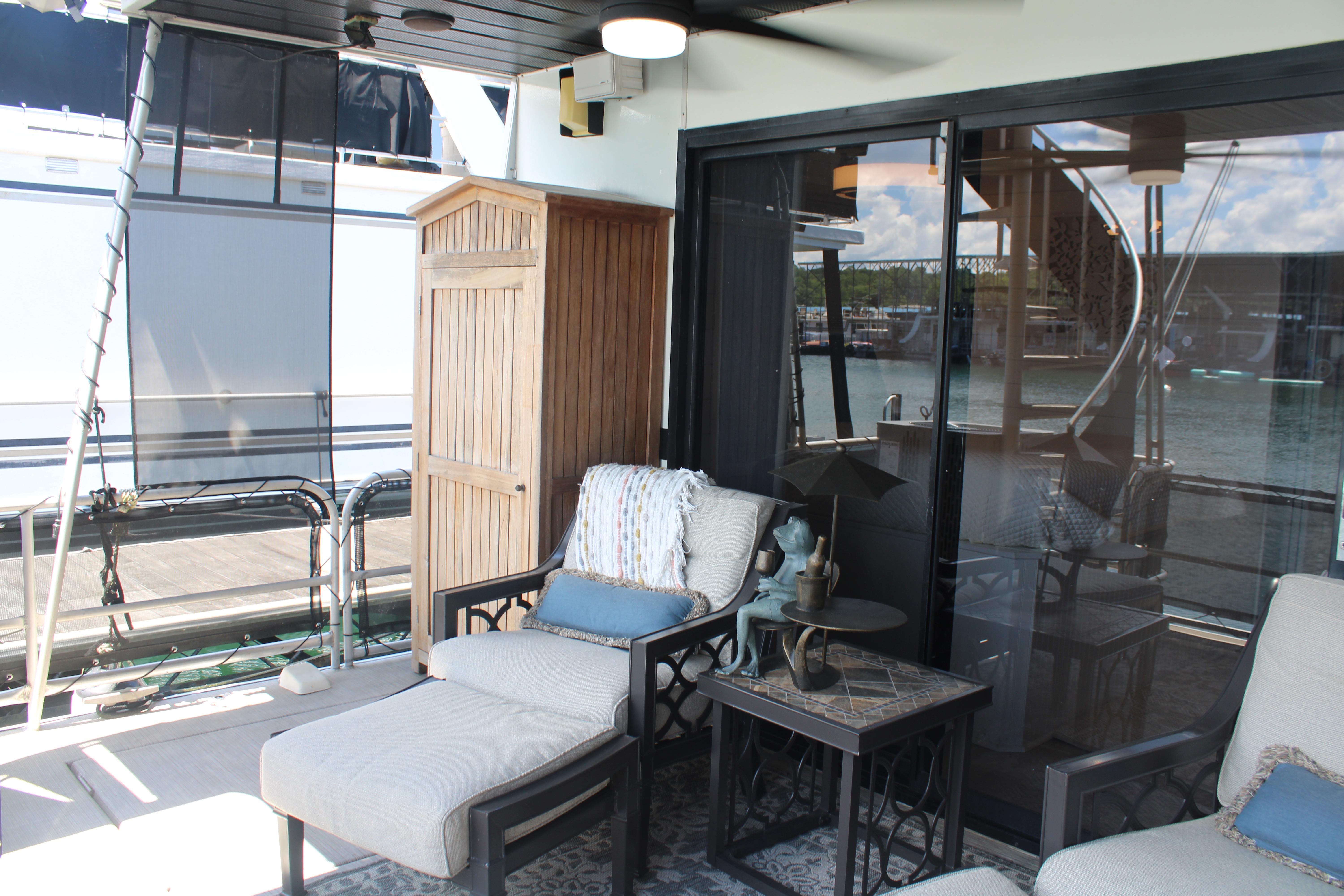 Cozy outdoor seating on 1992 Sumerset 66 houseboat with water view.