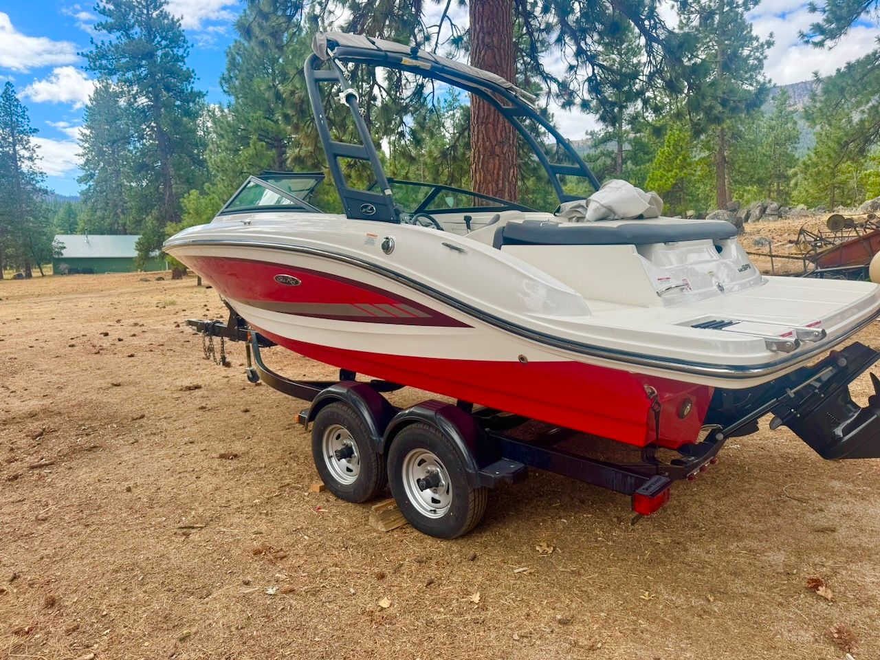 2016 Sea Ray SPX 190 Outboard on a trailer in a wooded area.
