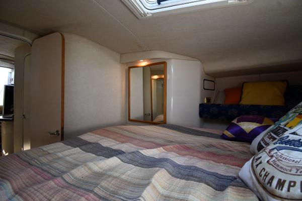 Cozy cabin interior of 1997 Sea Ray 400 Sundancer with bed and mirror.