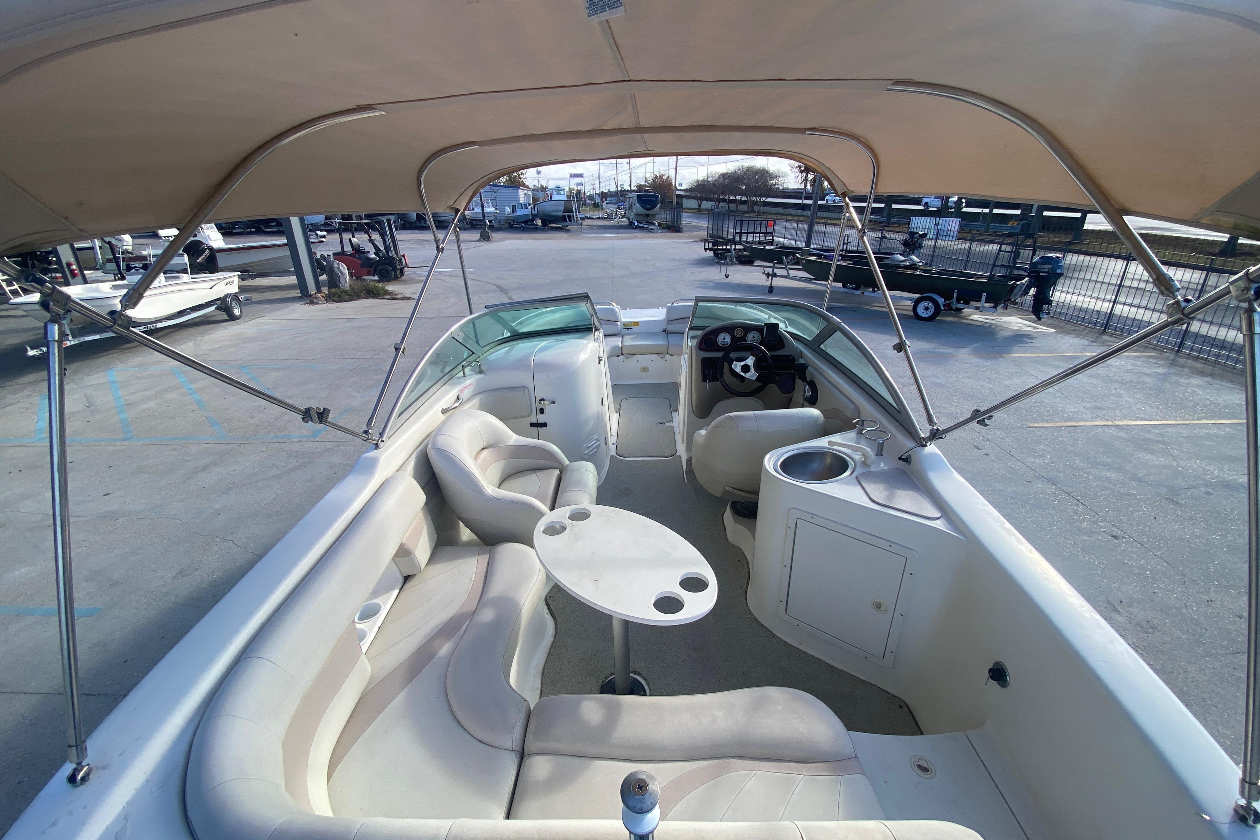 2007 NauticStar 230DC Sport Deck boat interior with seating, table, and canopy.