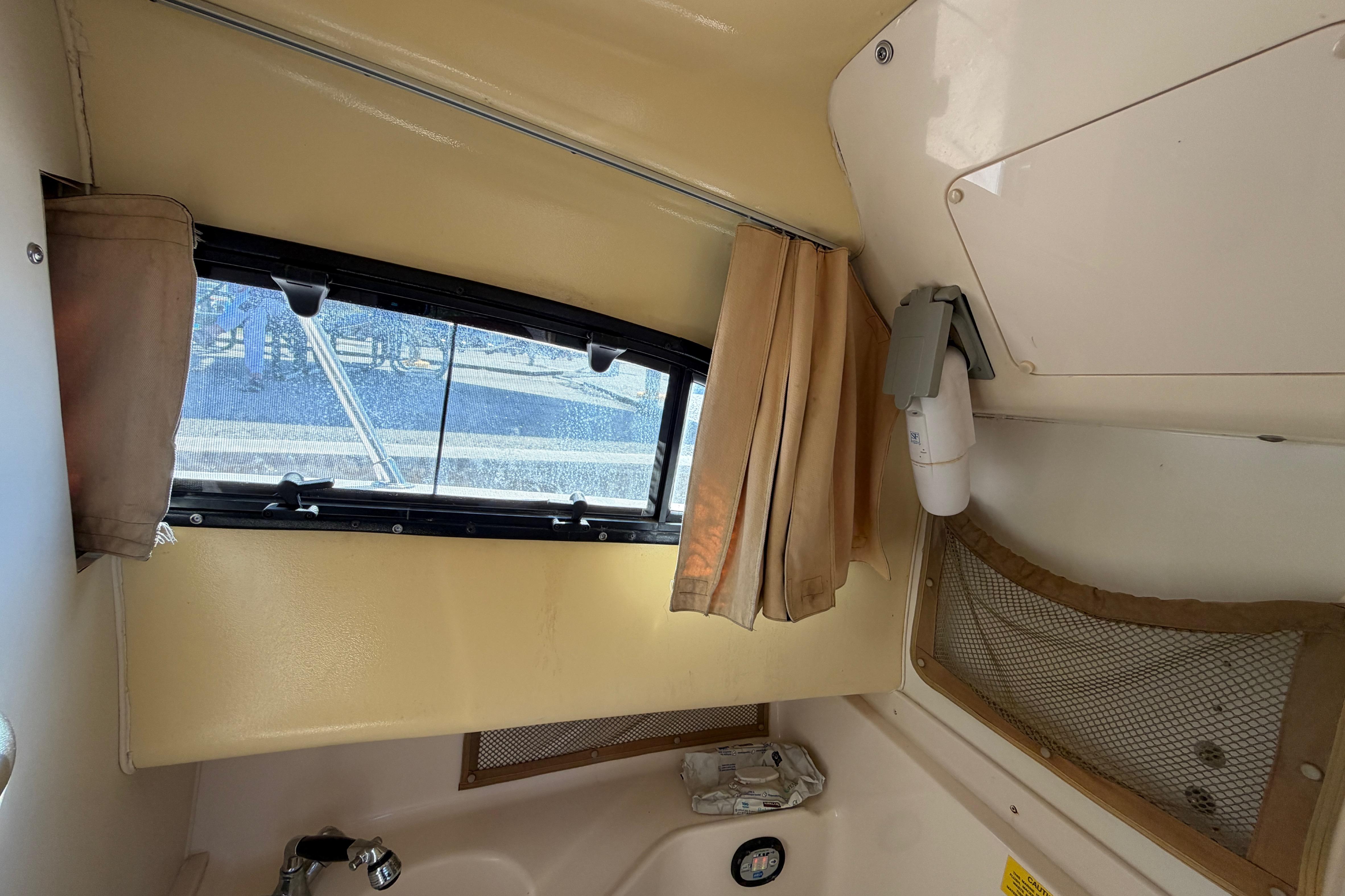Interior cabin of 2006 Grady-White Sailfish 282 boat with window and storage.