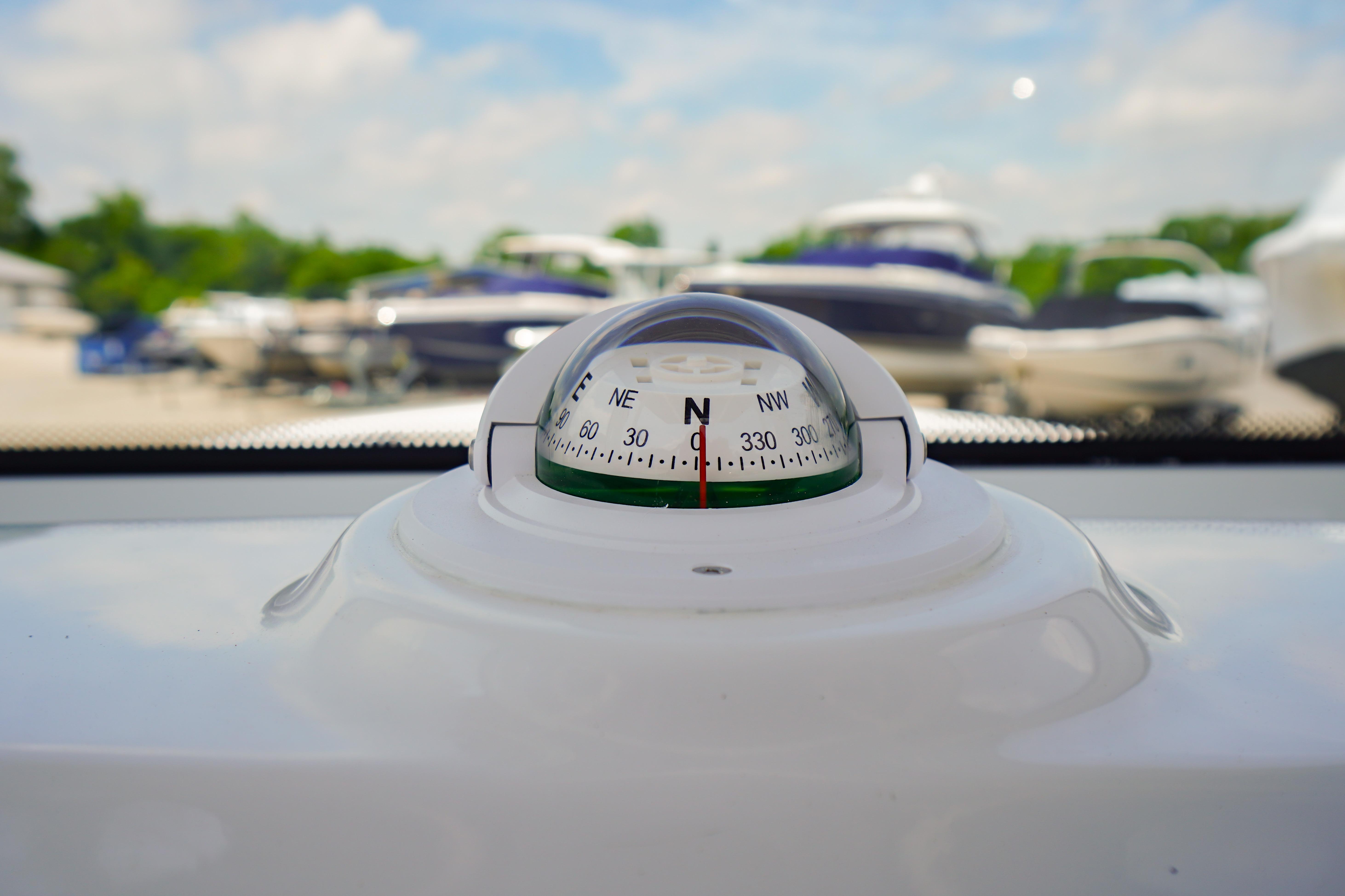 Compass on 2027 Tidewater 220 CC Adventure boat, with blurred marina background.