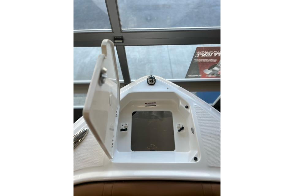 Open storage compartment on 2025 Chaparral 247 SSX boat, showcasing interior design.