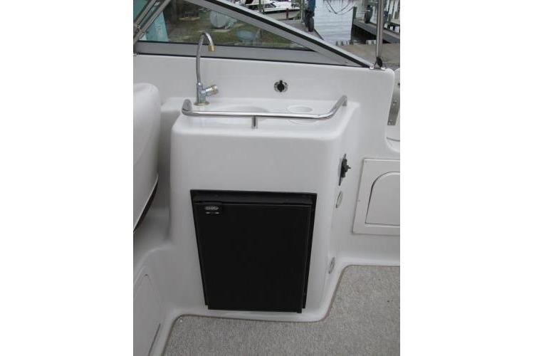 2004 Crownline 288 BR boat kitchenette with sink and mini fridge.