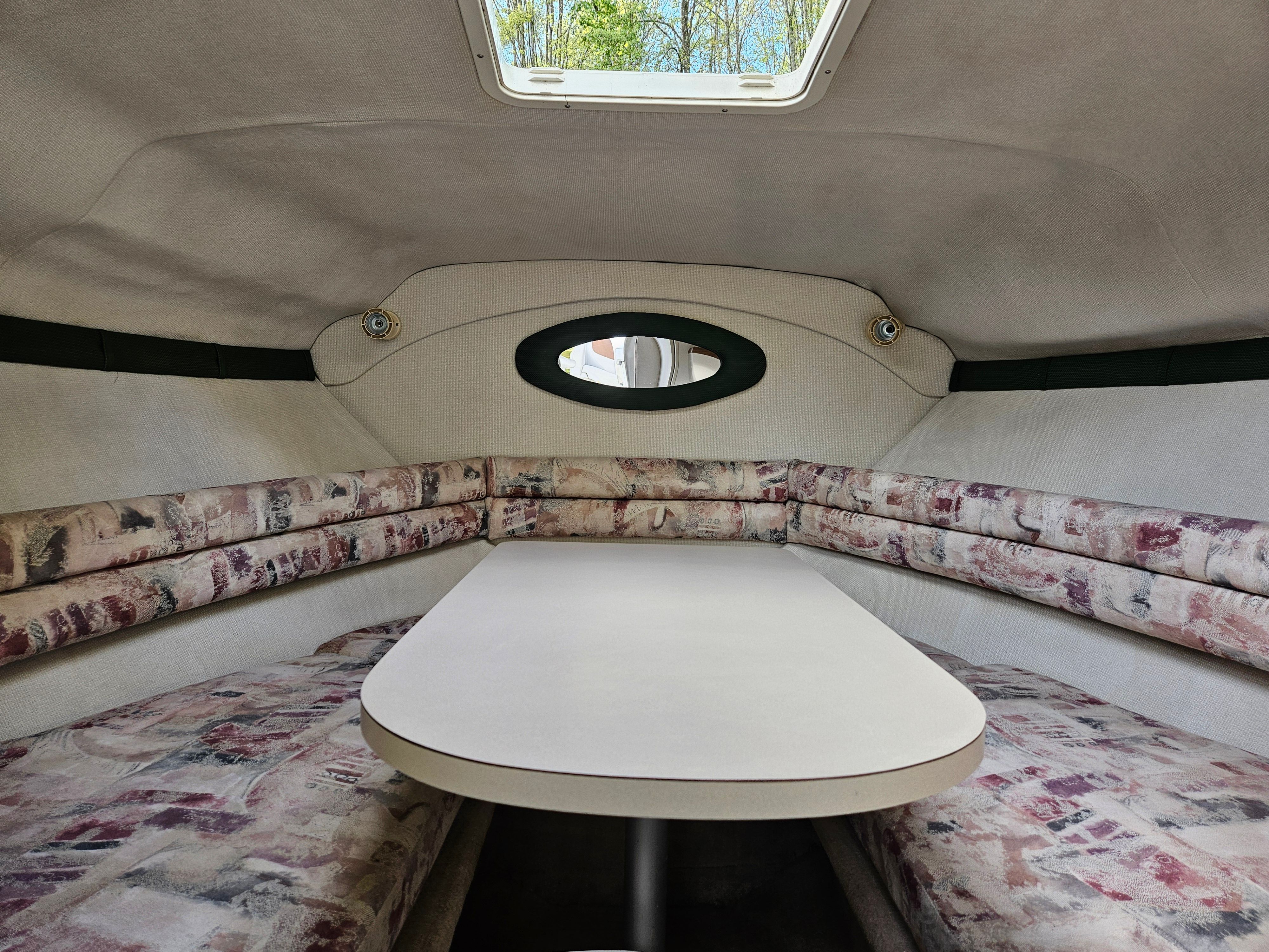 Interior of a 1998 Larson Cabrio 254 with table and seating area.